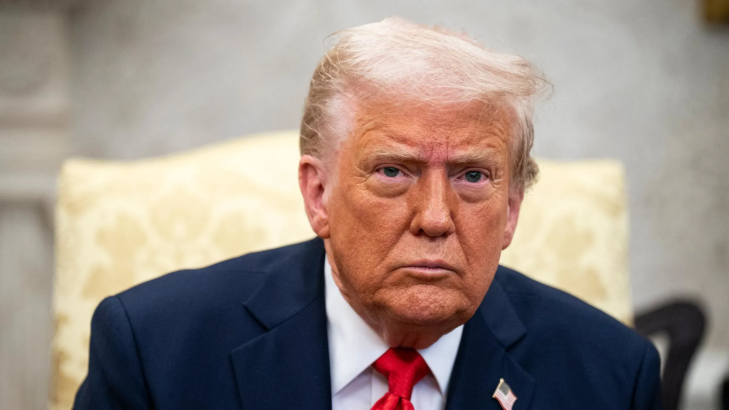 صورة لدونالد ترامب وهو يجلس بوجه عابس في المكتب البيضاوي، تعكس مشاعر القلق بشأن الاقتصاد والسياسات التجارية.