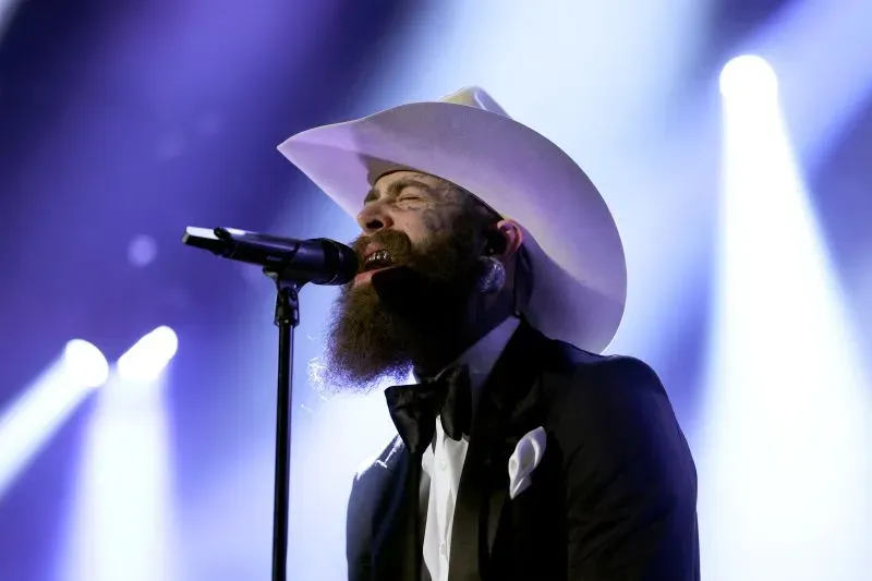 مغني يرتدي قبعة كبيرة ويؤدي على المسرح خلال مهرجان كوتشيلا، مع أضواء ساطعة تضيء خلفه.