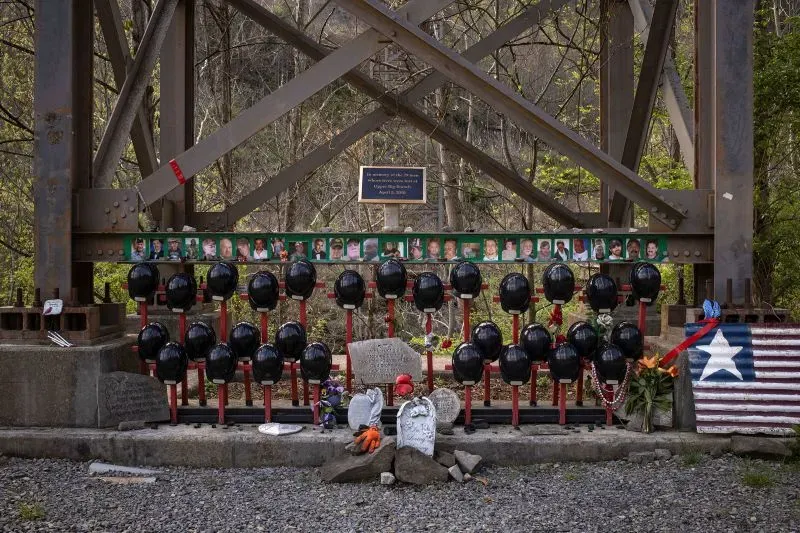 نصب تذكاري لعمال المناجم، يتضمن خوذات سوداء وصور للضحايا، في موقع يكرم ذكرى أولئك الذين فقدوا حياتهم في حوادث التعدين.