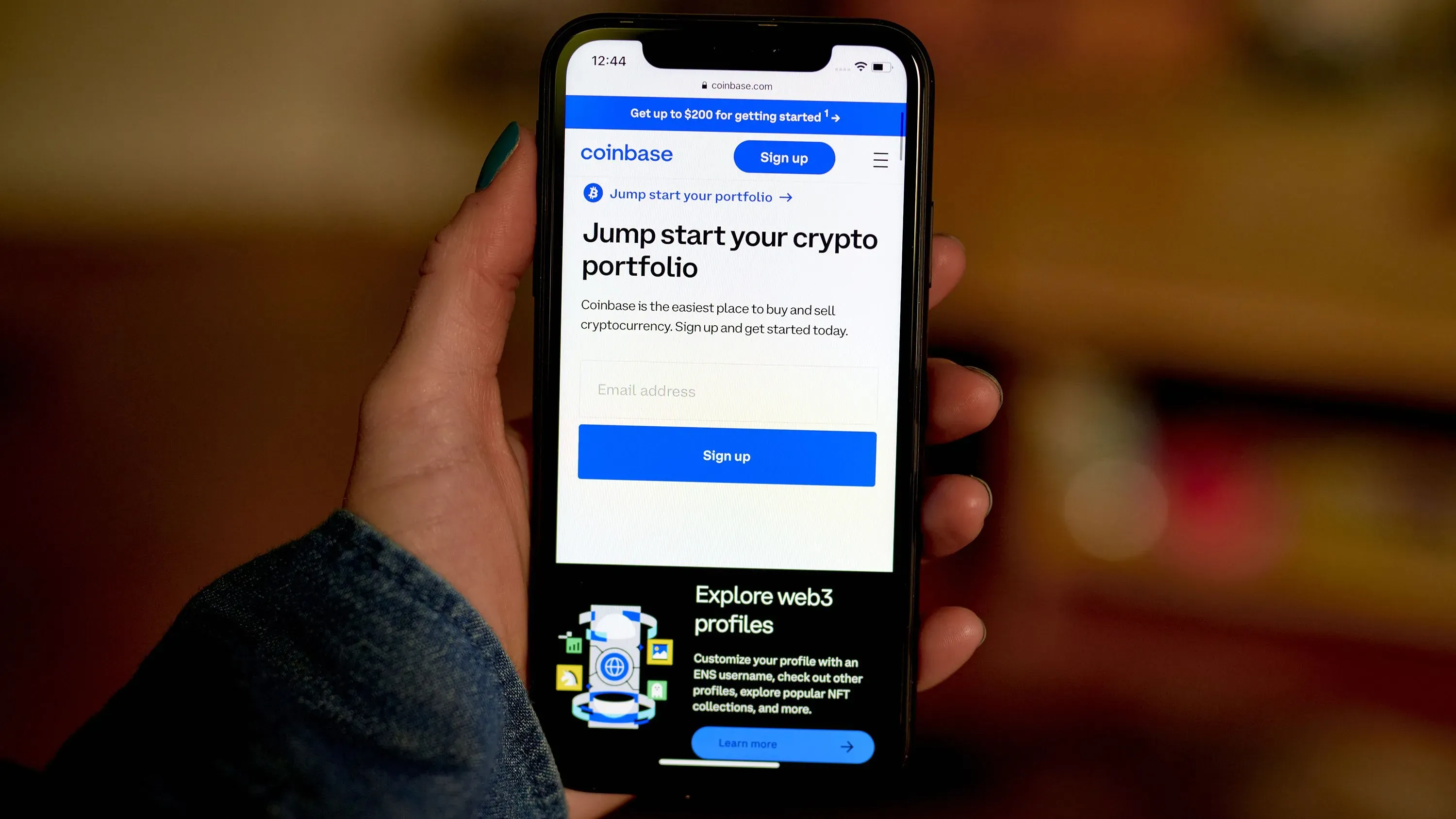 شاشة هاتف تعرض تطبيق Coinbase مع عبارة "ابدأ محفظتك الرقمية" وواجهة تسجيل دخول، تعكس التوجه نحو تنظيم العملات الرقمية.