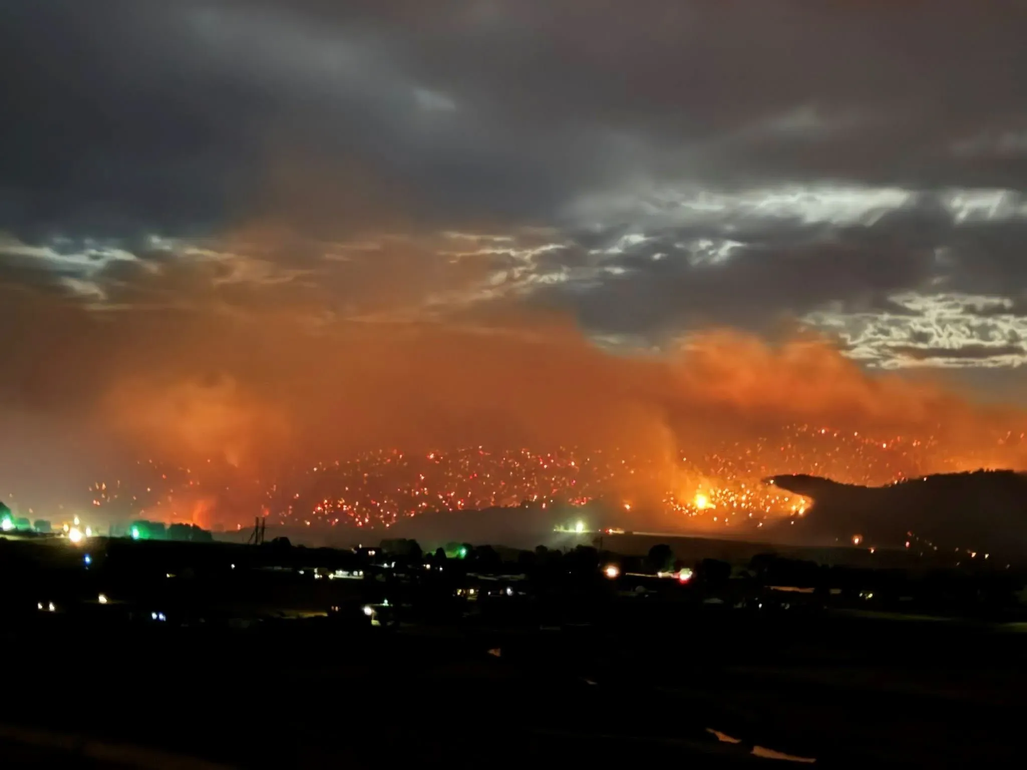 حرائق الغابات تشتعل في كولورادو، مع تصاعد الدخان واللهب في الأفق، مما يعكس حجم حريق لي فاير الذي يهدد المناطق المحيطة.