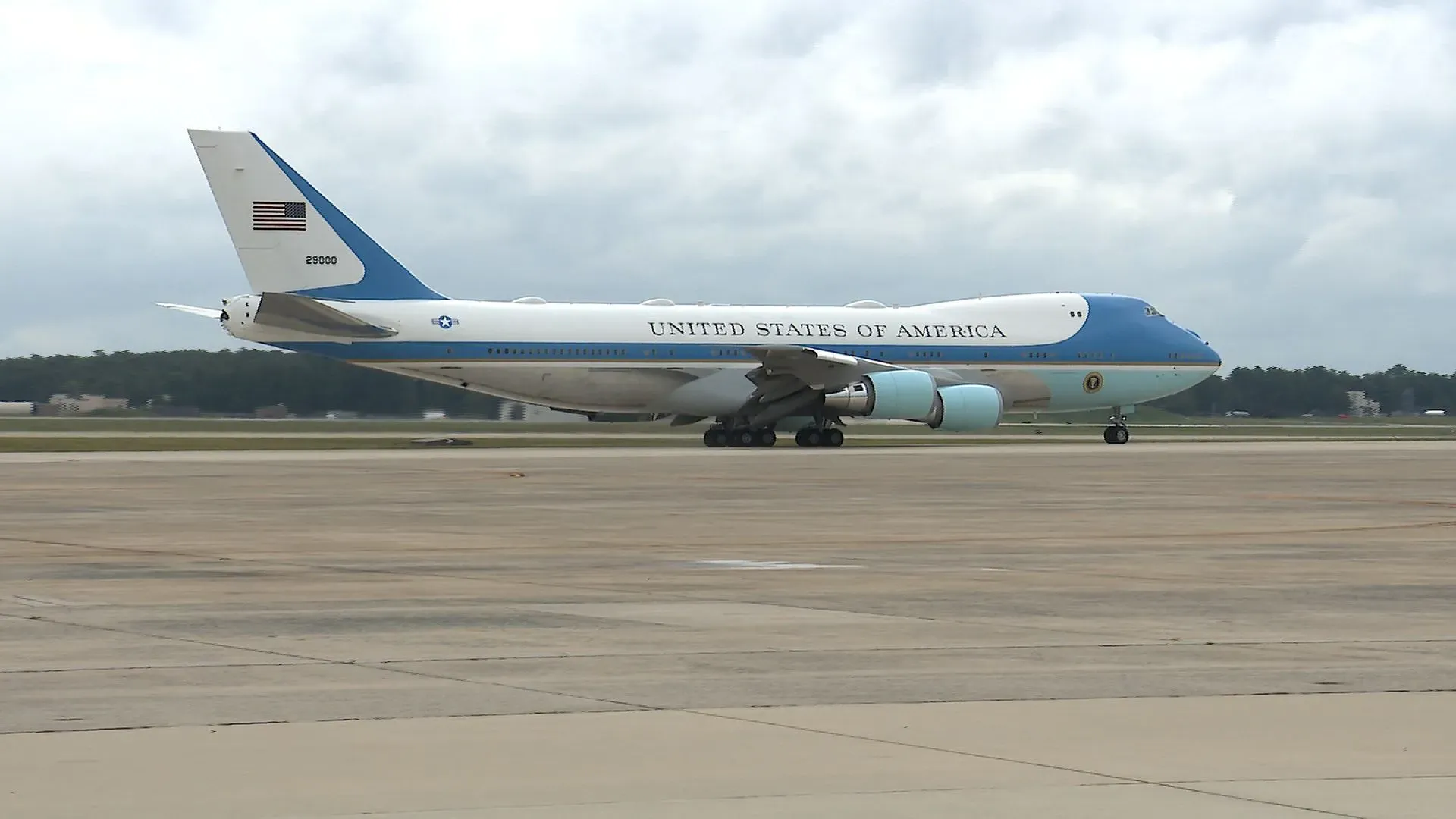 طائرة إير فورس وان، المخصصة لنقل الرئيس الأمريكي، أثناء الإقلاع، مع خلفية غائمة تشير إلى ظروف الطقس.