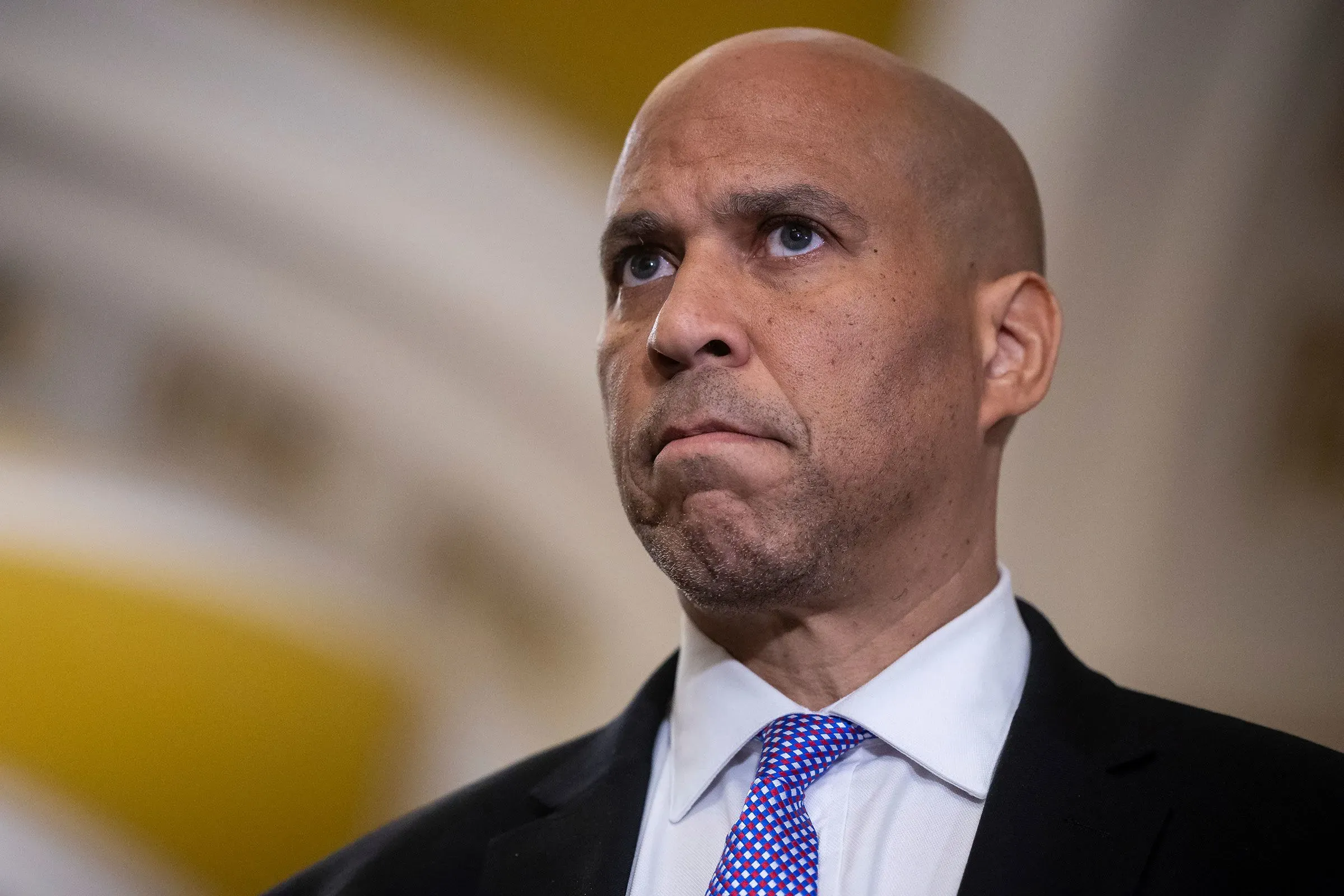 يظهر السيناتور كوري بوكر بملامح جدية أثناء حديثه عن ضرورة مقاومة ترامب، مشددًا على أهمية دعم الديمقراطيين للقضايا الشعبية.