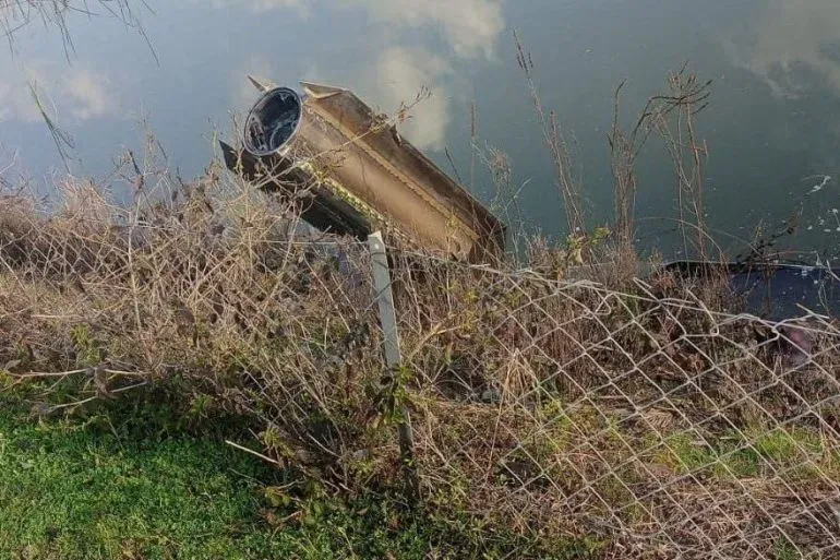 حطام صاروخ إيراني بالقرب من مجرى مائي، يظهر تفاصيل الهيكل المعدني والغطاء العلوي، مما يشير إلى الاستخدام العسكري المحتمل.