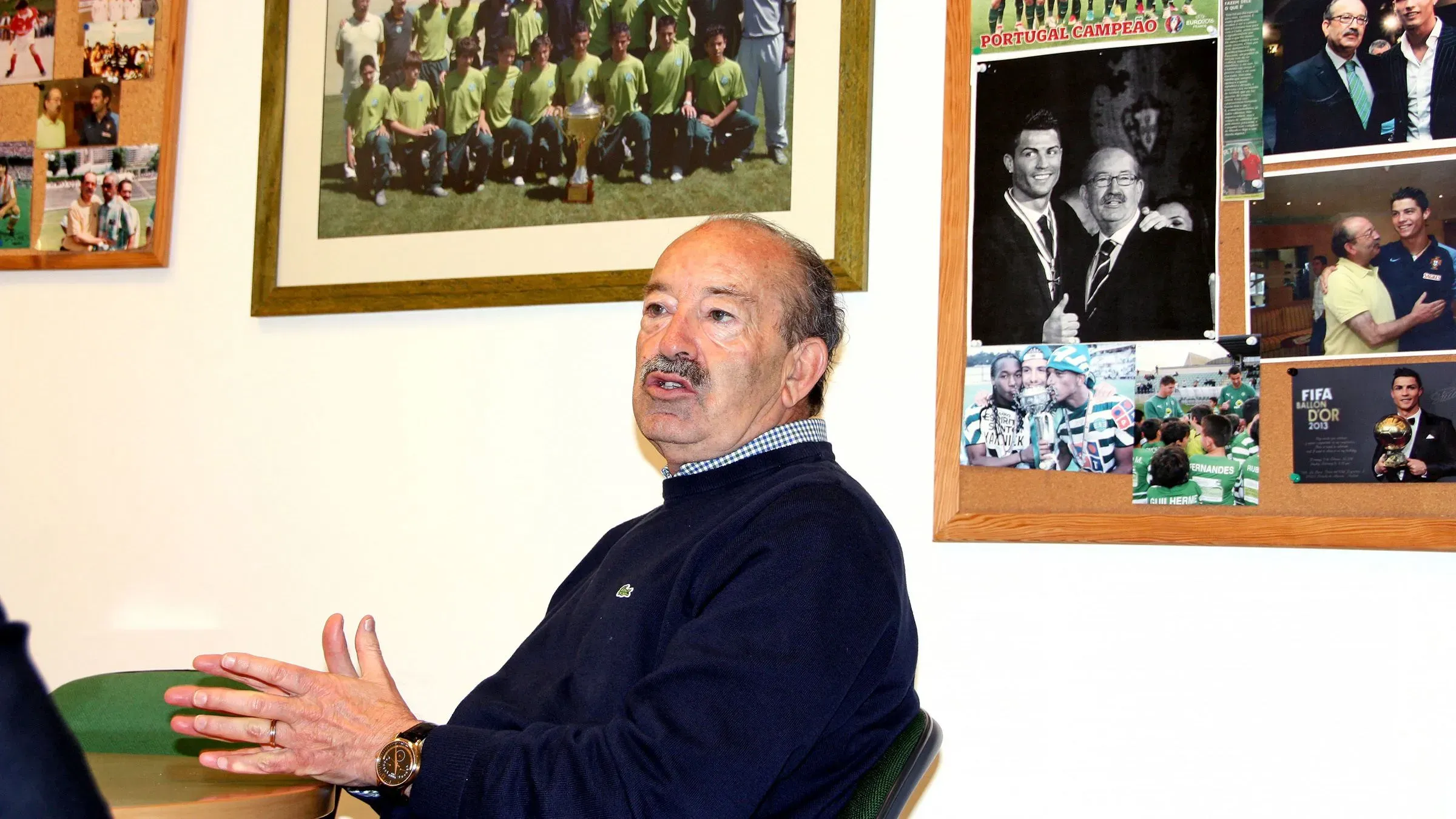 تظهر الصورة أوريليو بيريرا، الكشاف البرتغالي الشهير، أثناء حديثه، محاطًا بصور تذكارية مع لاعبين مشهورين مثل كريستيانو رونالدو.