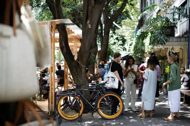 مظاهرة في مكسيكو سيتي ضد ارتفاع تكاليف المعيشة، مع وجود متظاهرين يحملون لافتات ودراجات على الرصيف.