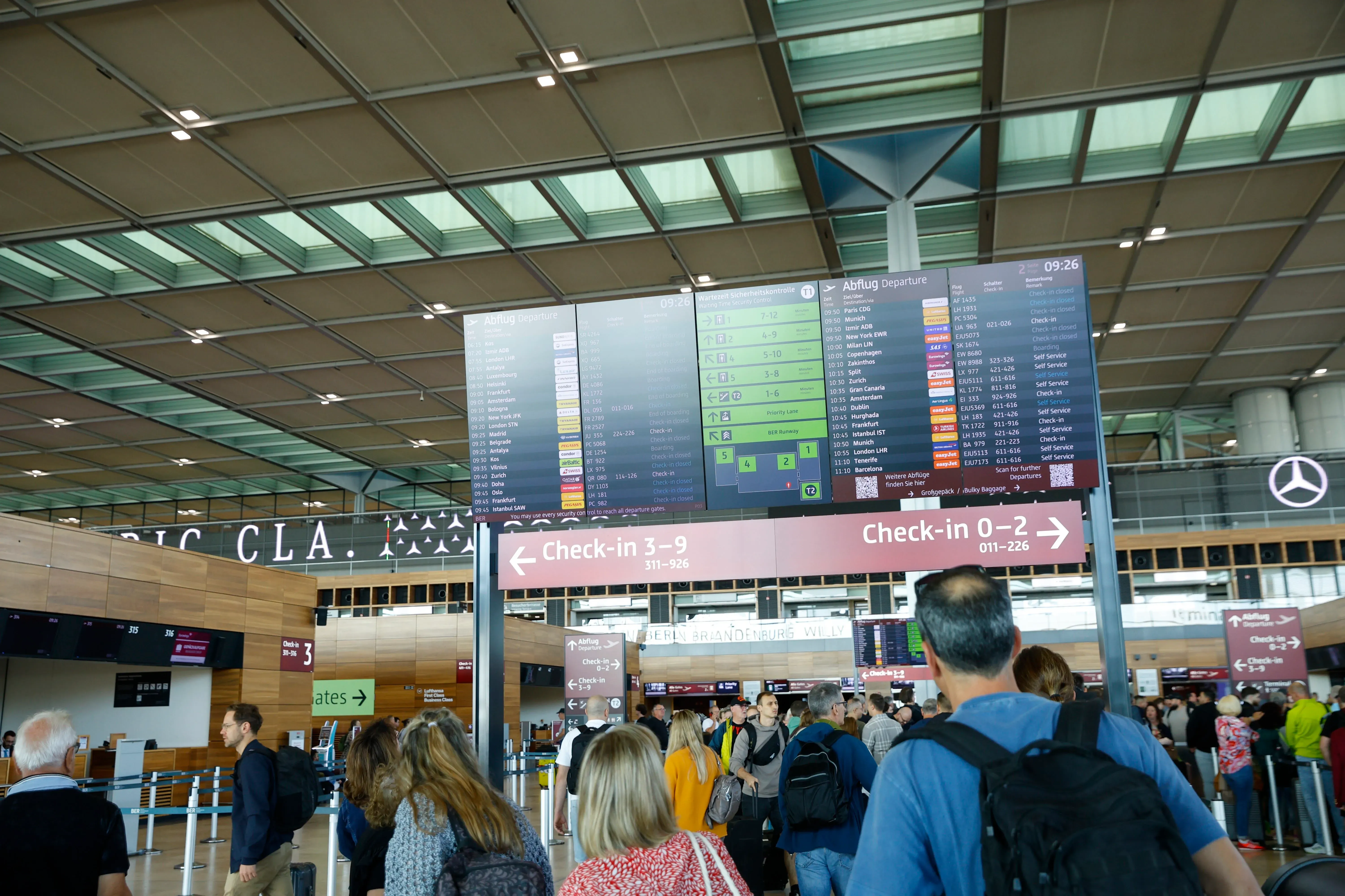 ازدحام في مطار مع شاشات عرض توضح معلومات الرحلات، وسط تأثير هجوم إلكتروني على أنظمة تسجيل الوصول في عدة مطارات أوروبية.