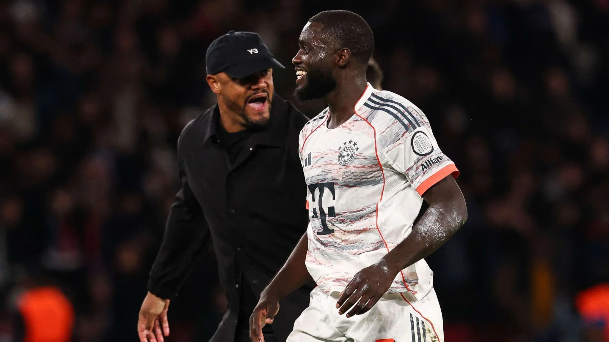دايوت أوباميكانو لاعب بايرن ميونخ يبتسم أثناء حديثه مع مدربه في مباراة كرة قدم ضمن الدوري الألماني.