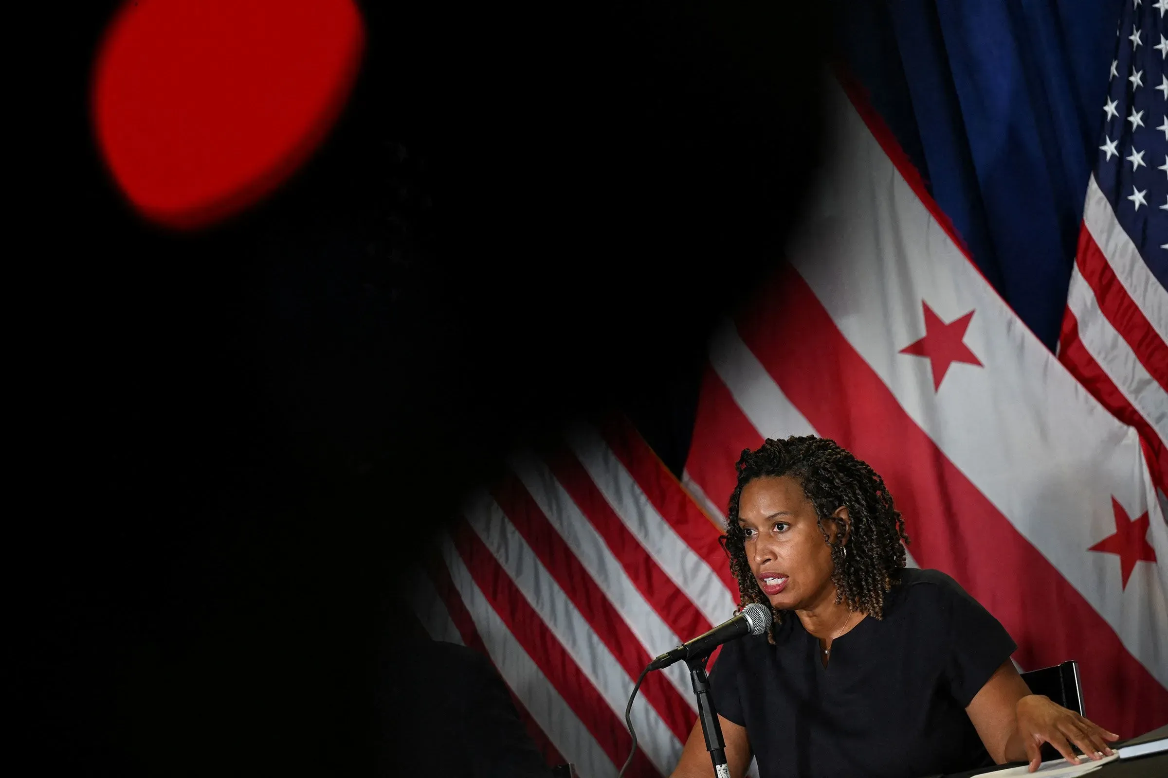 عمدة واشنطن مورييل باوزر تتحدث في مؤتمر صحفي، خلفها الأعلام الأمريكية، مؤكدةً على إنهاء حالة الطوارئ الفيدرالية.