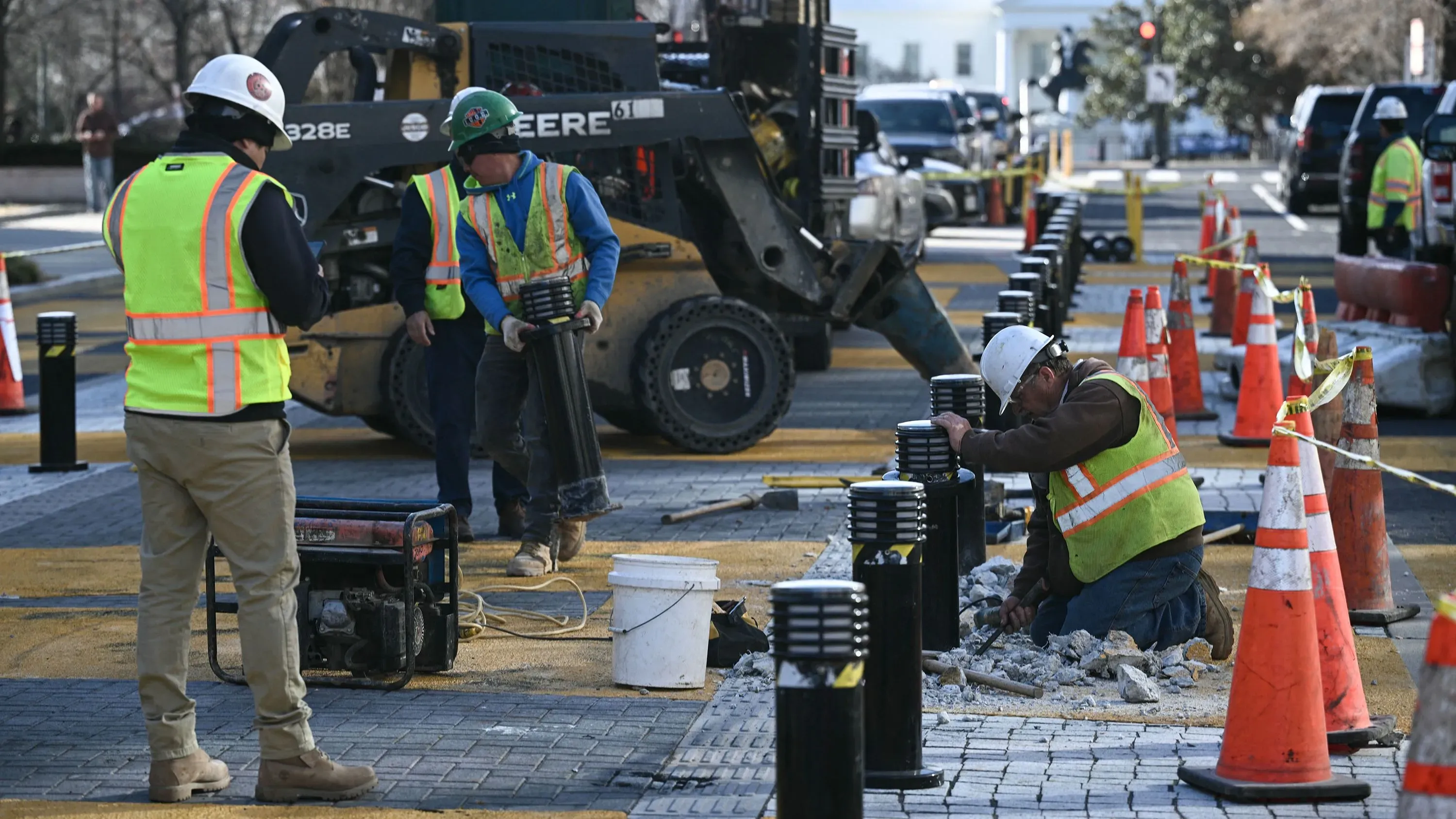 عمال يقومون بإزالة أجزاء من ساحة "بلاك لايفز ماتر بلازا" في واشنطن، مع وجود معدات بناء وحواجز مرورية، في سياق ضغوط سياسية.