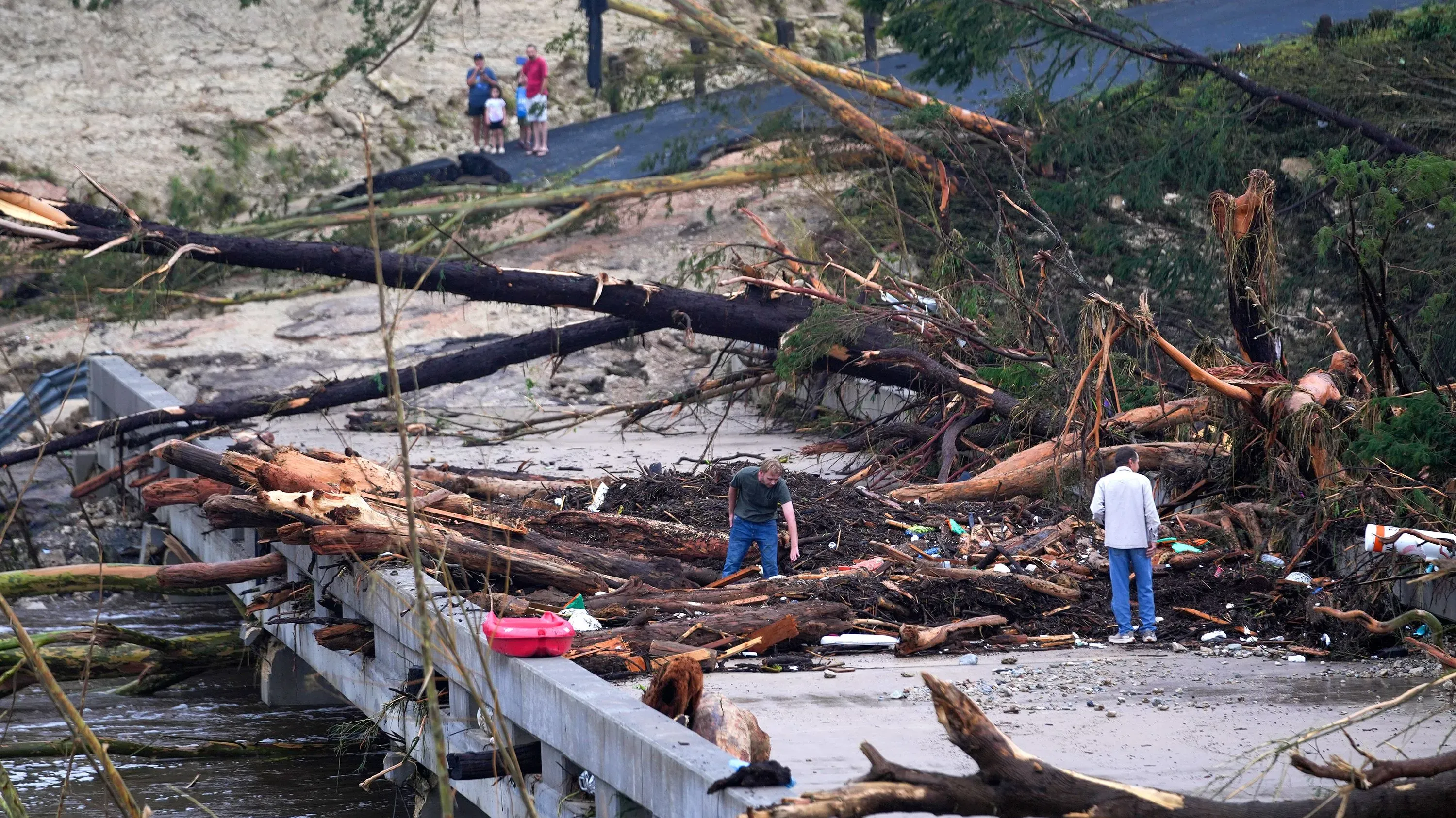 أشخاص يقومون بتنظيف حطام الأشجار والنفايات بعد الفيضانات في وسط تكساس، حيث تضررت المنطقة بشكل كبير جراء الأمطار الغزيرة.