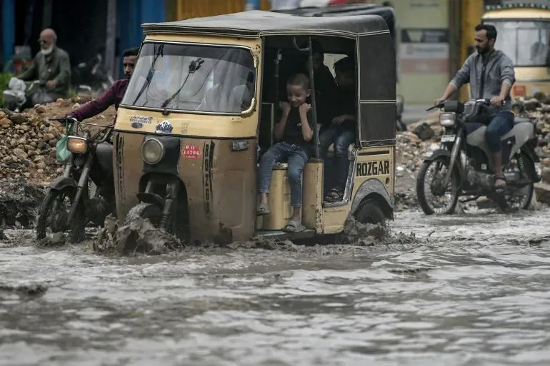 مركبة ثلاثية العجلات تسير في مياه الفيضانات في باكستان، حيث تسببت الأمطار الغزيرة في أضرار جسيمة ووفاة العديد من الأشخاص.