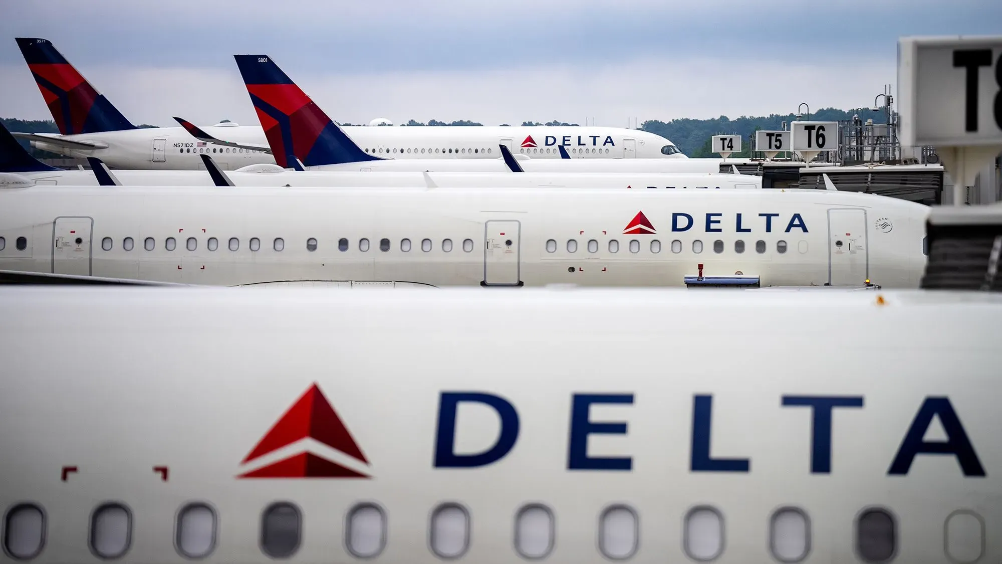 طائرات شركة دلتا متوقفة في المطار، مما يعكس التحديات الاقتصادية الحالية وتأثيرها على خطط النمو في الإيرادات.