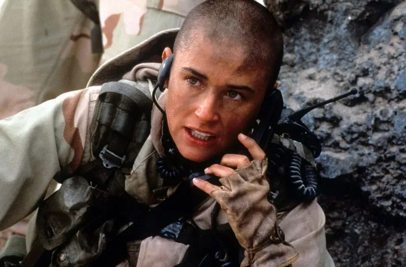 ديمي مور في دورها كأول امرأة في البحرية الأمريكية بفيلم "G.I. Jane"، تظهر بملابس عسكرية وحلاقة رأس جريئة.