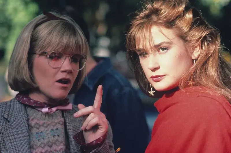 مشهد من فيلم "حريق سانت إلمو" (1985) يظهر ديمي مور بشعرها الطويل، تتحدث مع شخصية أخرى ترتدي نظارات.