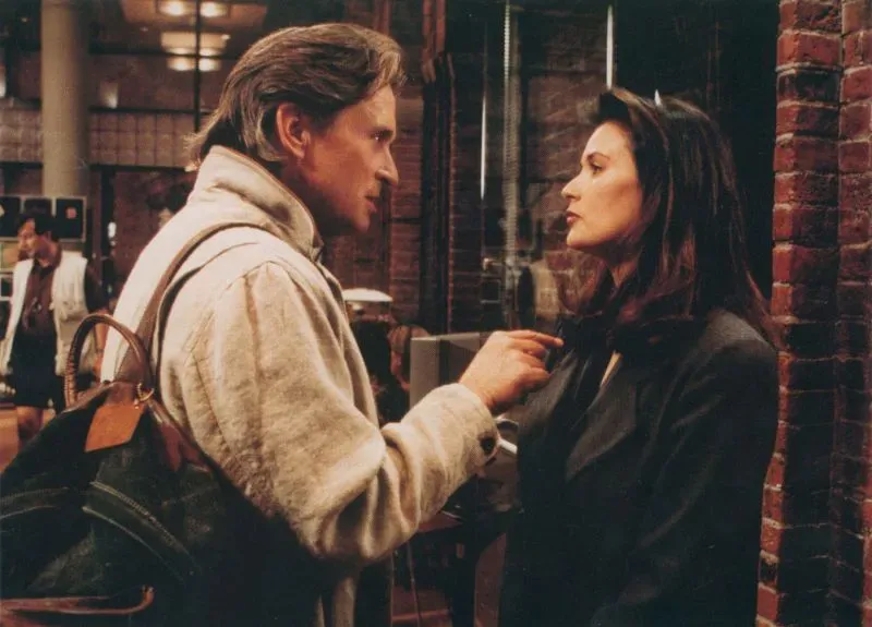 مشهد من فيلم "الإفصاح" (1994) يظهر ديمي مور في دور مديرة تنفيذية تواجه تحرشاً جنسياً، مع التركيز على التوتر بين الشخصيتين.