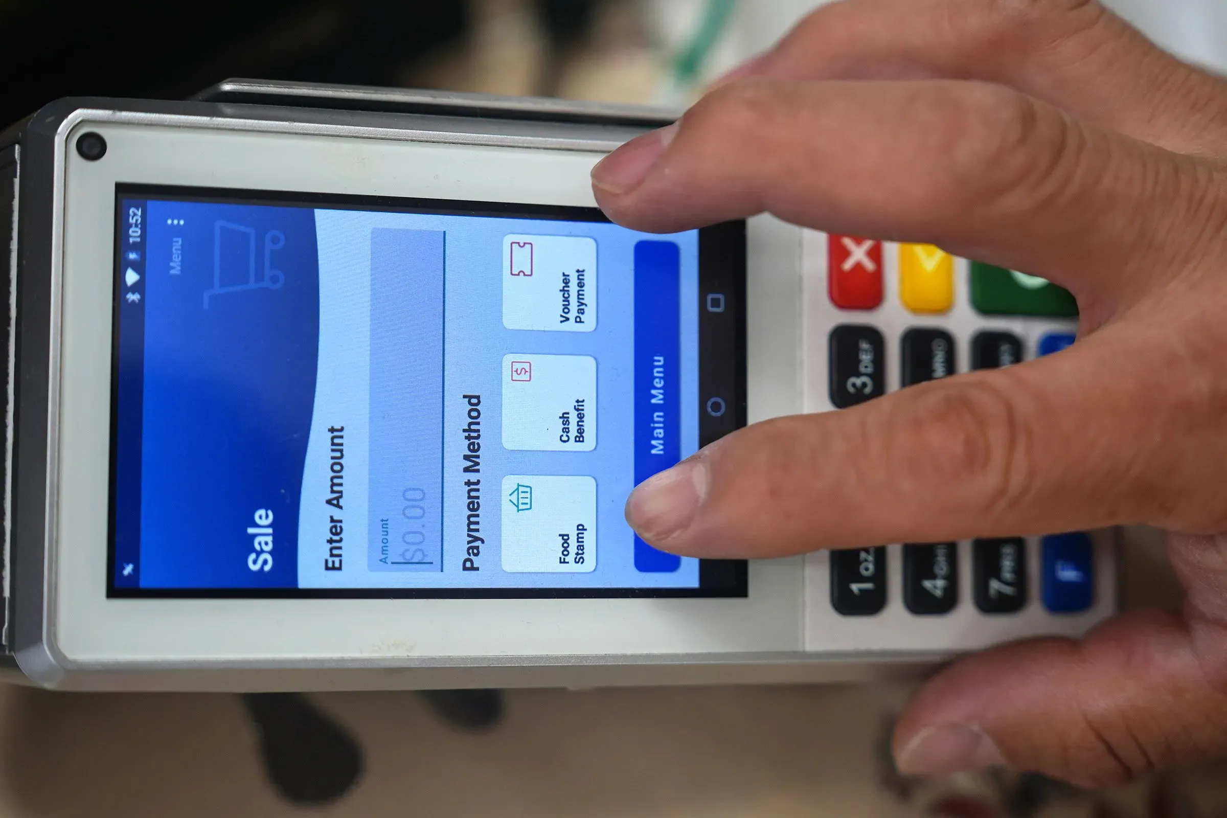 جهاز دفع إلكتروني يُظهر خيارات للدفع، بما في ذلك طوابع الغذاء، في سياق مناقشات حول تخفيضات المساعدات الغذائية الفيدرالية.