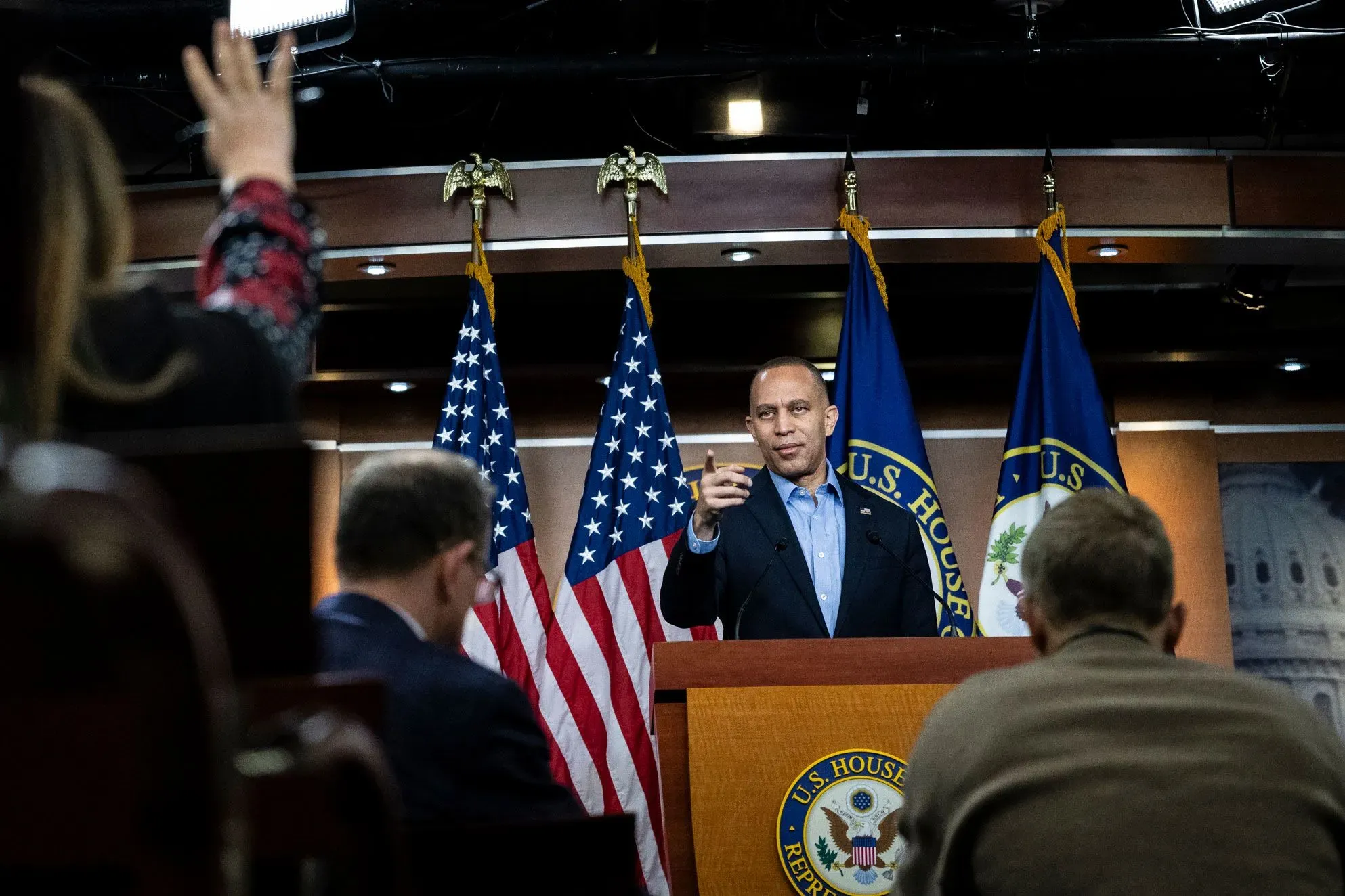 زعيم الأقلية في مجلس النواب حكيم جيفريز يتحدث خلال مؤتمر صحفي، مع وجود أعلام أمريكية خلفه.