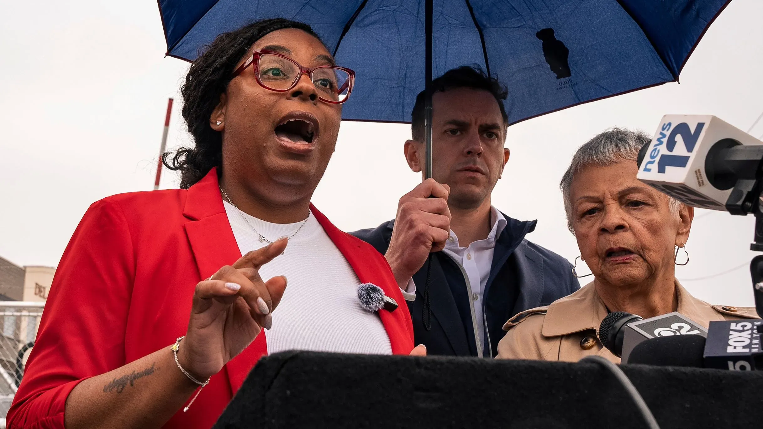 تظهر النائبة بوني واتسون كولمان تتحدث بحماس أثناء مؤتمر صحفي خارج منشأة إدارة الهجرة والجمارك في نيوارك، نيوجيرسي.