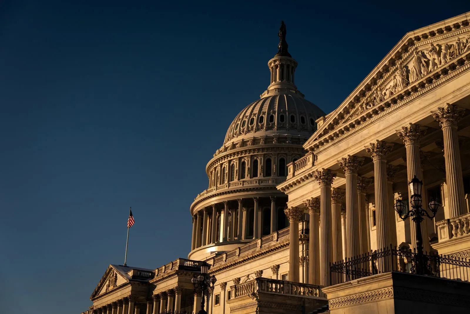 مبنى الكابيتول الأمريكي تحت أشعة الشمس، مع تفاصيل معمارية بارزة، يمثل مركزًا للقرارات السياسية حول تمويل الحكومة.
