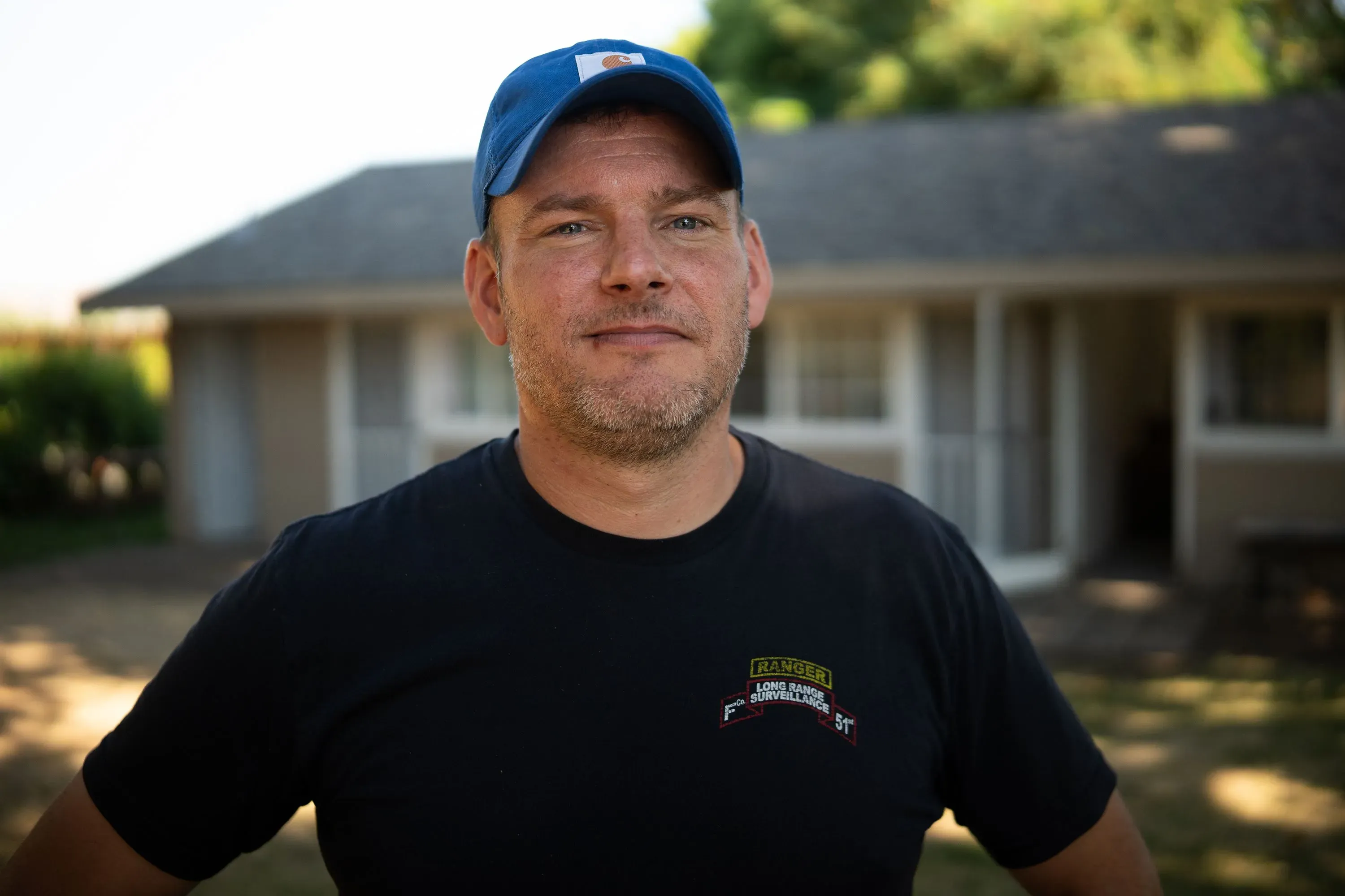 مزارع يقف أمام منزله، يعبّر عن قلقه حول نقص العمالة في حصاد الكرز، مما أدى إلى فقدان الإيرادات.