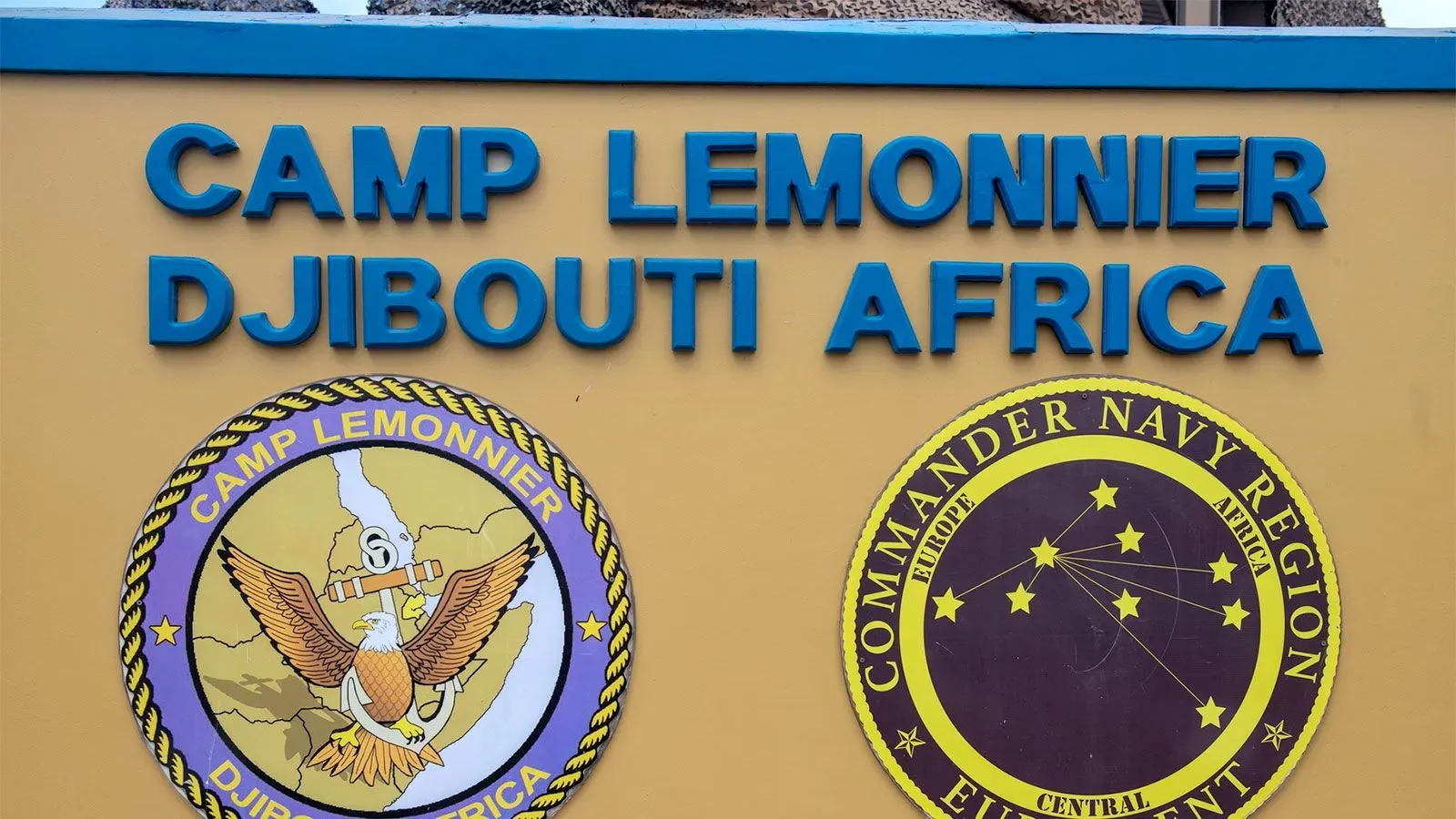 لافتة مع معلومات عن قاعدة ليمونييه العسكرية في جيبوتي، تشمل شعار القاعدة واسمها، تعكس الوضع الحالي للمهاجرين المحتجزين.