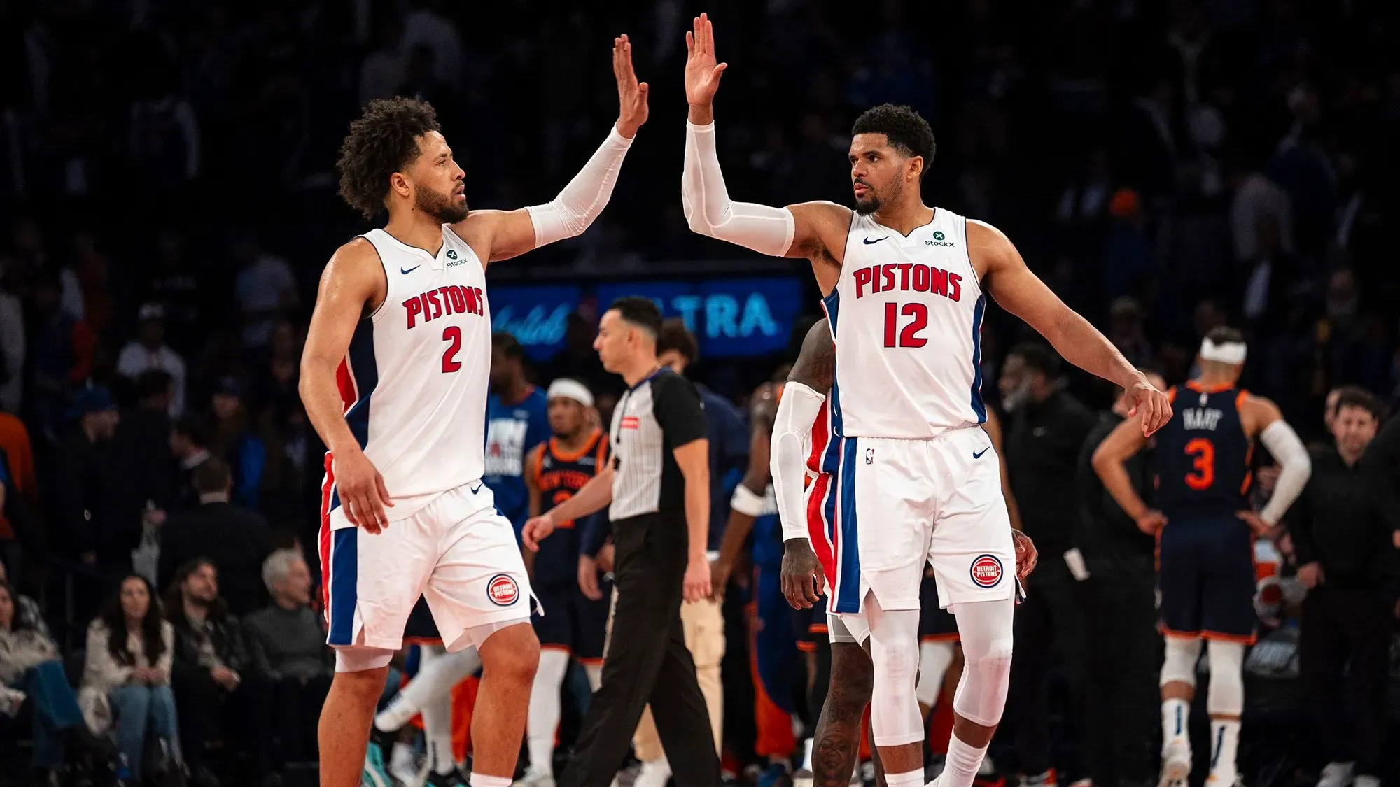 نجوم فريق ديترويت بيستونز يحتفلون بفوزهم على نيويورك نيكس في مباراة حاسمة بالدوري الأمريكي للمحترفين، مع تفاعل جماهيري ملحوظ.
