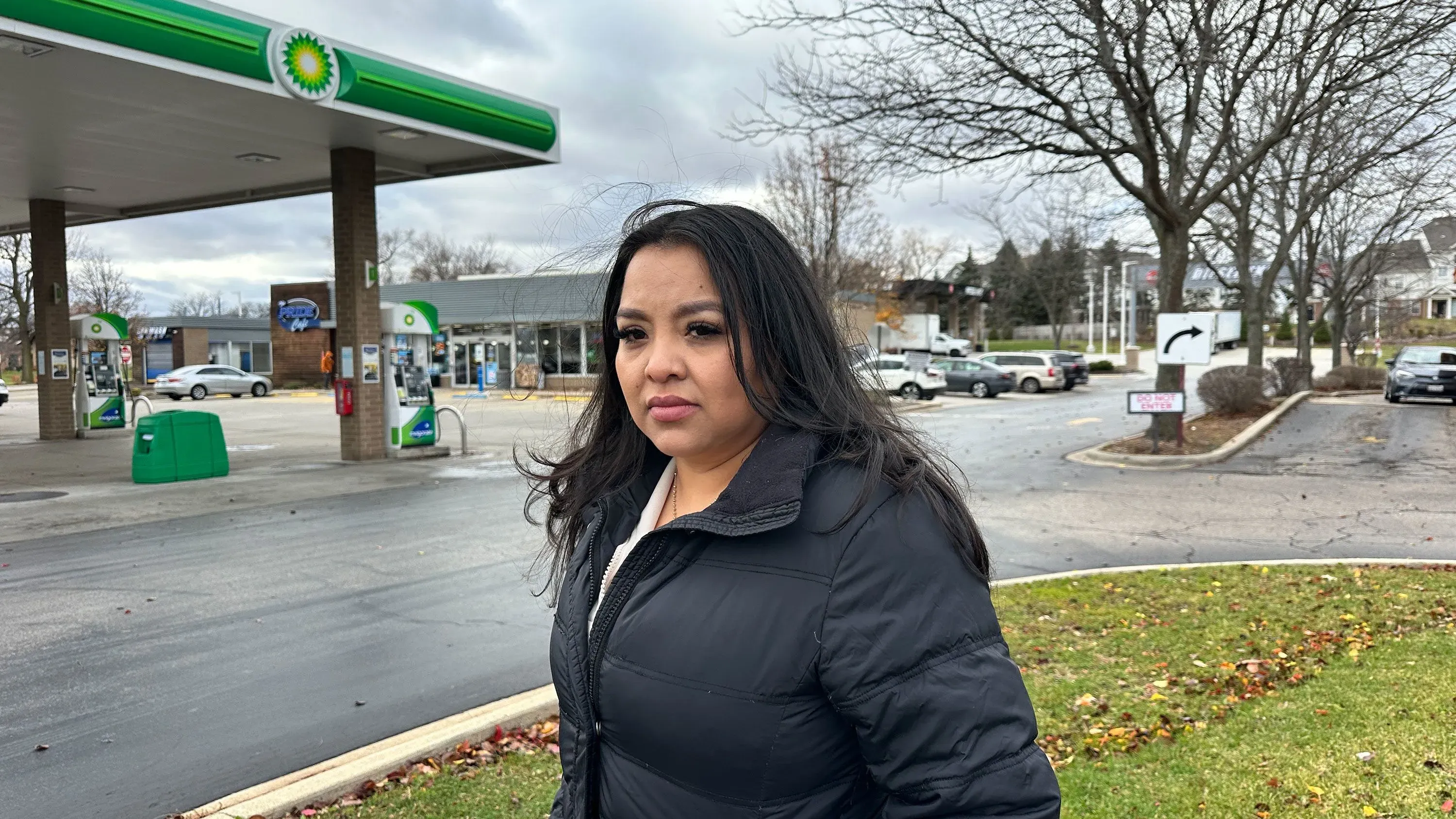 امرأة من أصول لاتينية تقف أمام محطة وقود في إلينوي، تعبر عن قلقها بعد اعتقالها المفاجئ خلال مداهمة للهجرة.