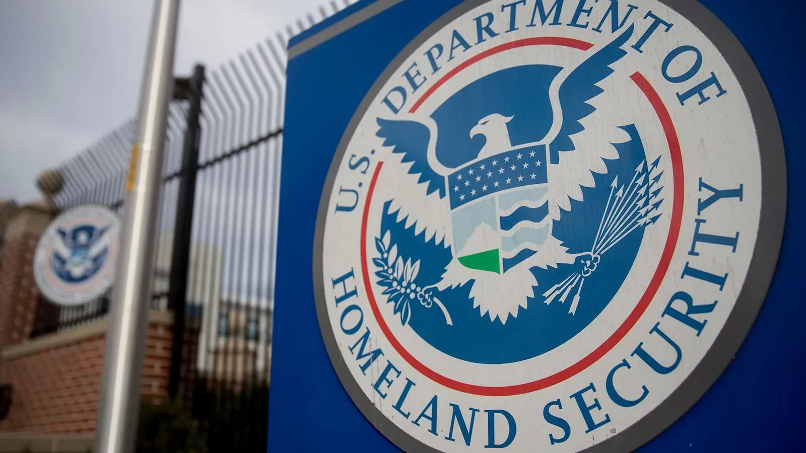 شعار وزارة الأمن الداخلي الأمريكية، مع التركيز على رموز الأمن والحماية، في سياق التخفيضات المخطط لها في مكتب الاستخبارات.