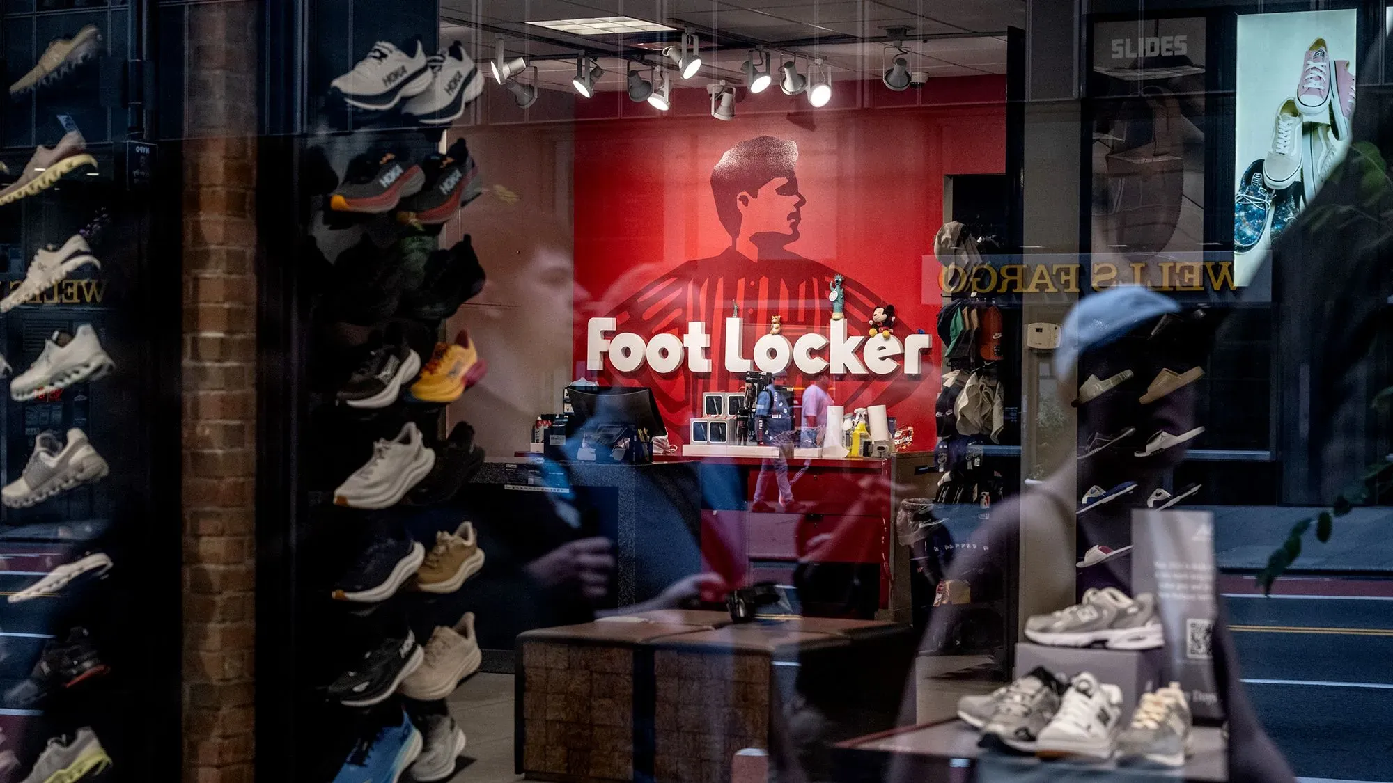 واجهة متجر فوت لوكر تعرض مجموعة من الأحذية الرياضية، مع شعار الشركة بارزًا على الجدار الخلفي، تعكس التطورات في صناعة التجزئة للأحذية.