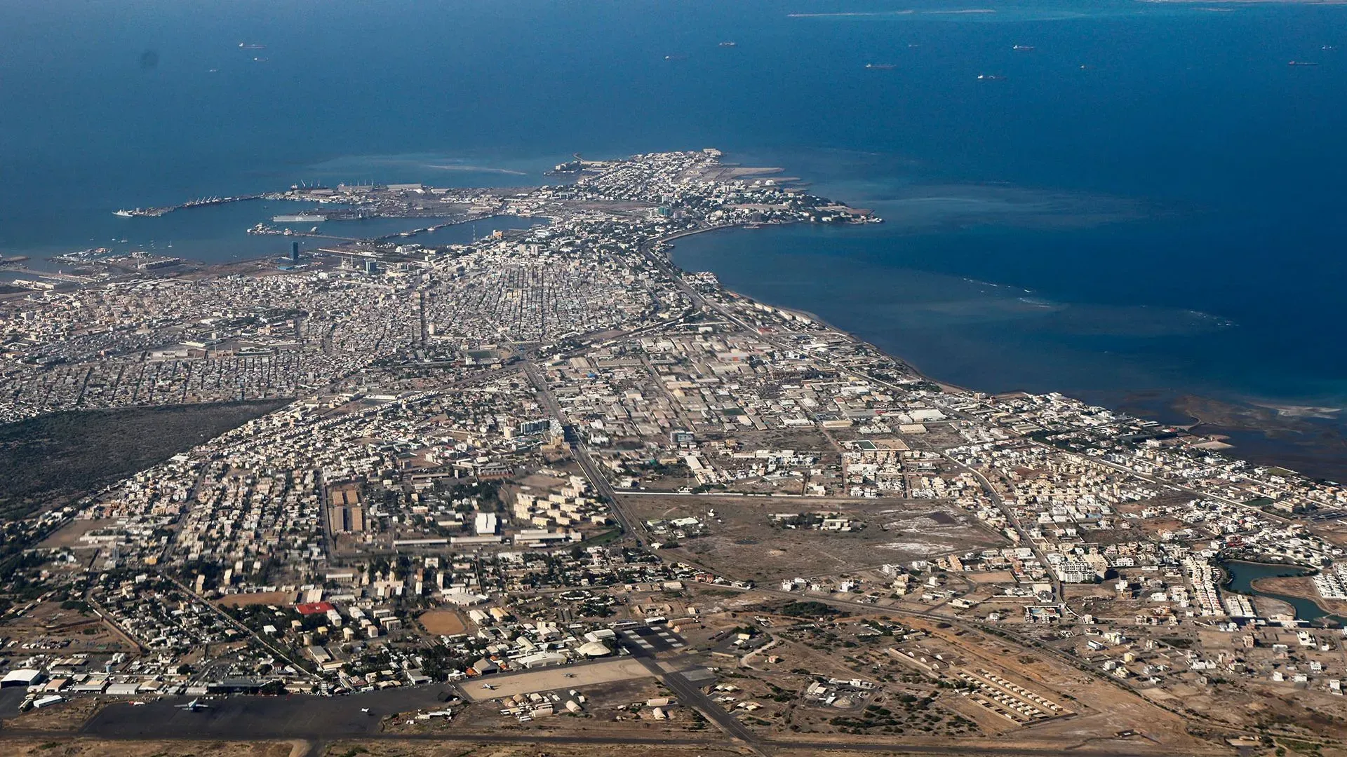 صورة جوية لمدينة جيبوتي، تُظهر الميناء والمناطق العمرانية، في سياق نقل مهاجرين إلى جنوب السودان.