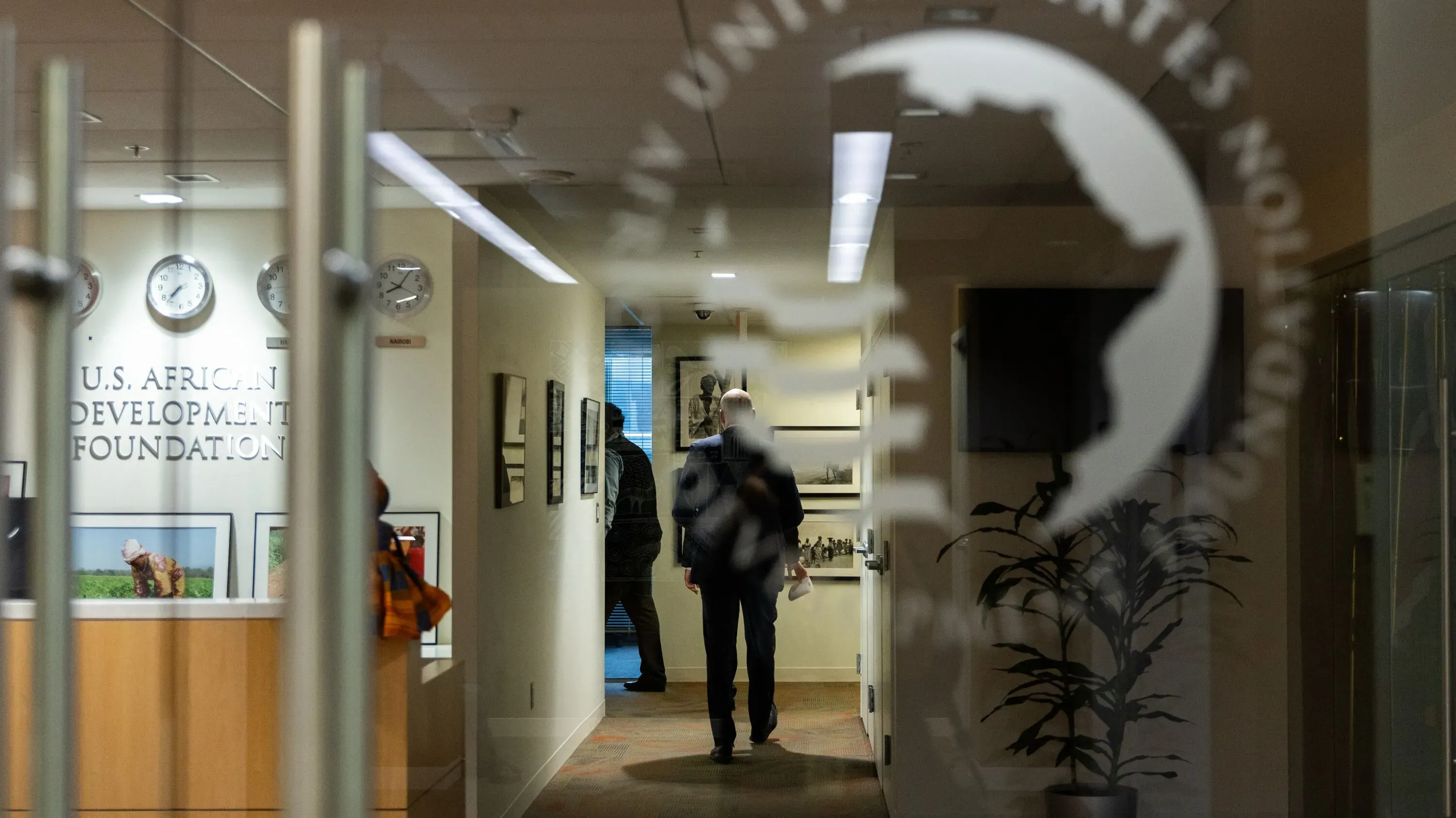 واجهة مؤسسة التنمية الأفريقية الأمريكية، مع موظف يسير في الممر، تعكس التوترات السياسية حول المساعدات الخارجية.