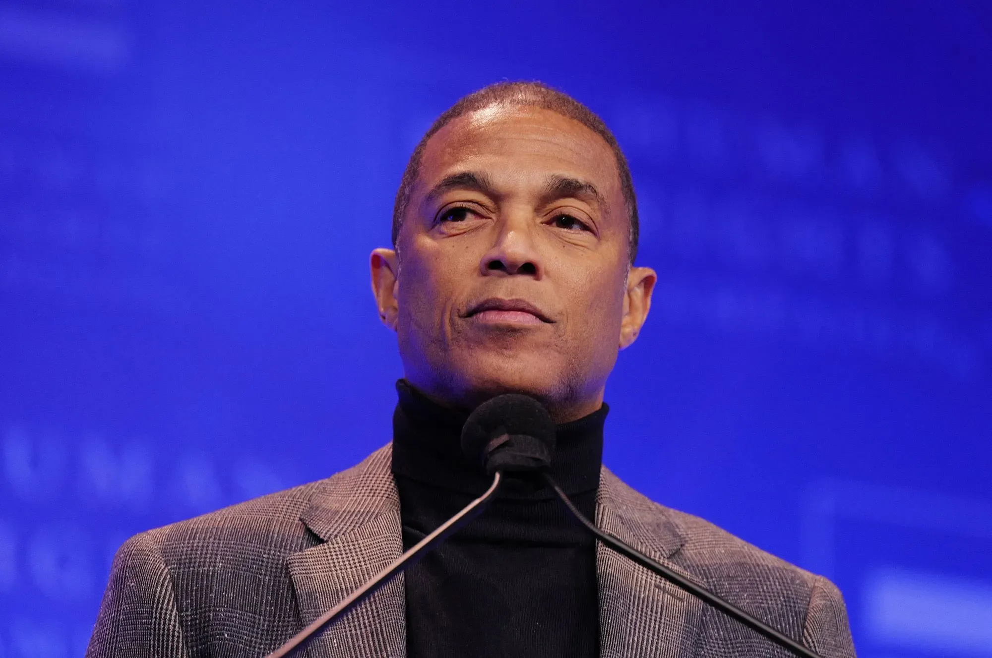 دون ليمون يتحدث في حدث عام، مع التركيز على تعبيره الجاد، في سياق قضيته القانونية المتعلقة بالمظاهرات.