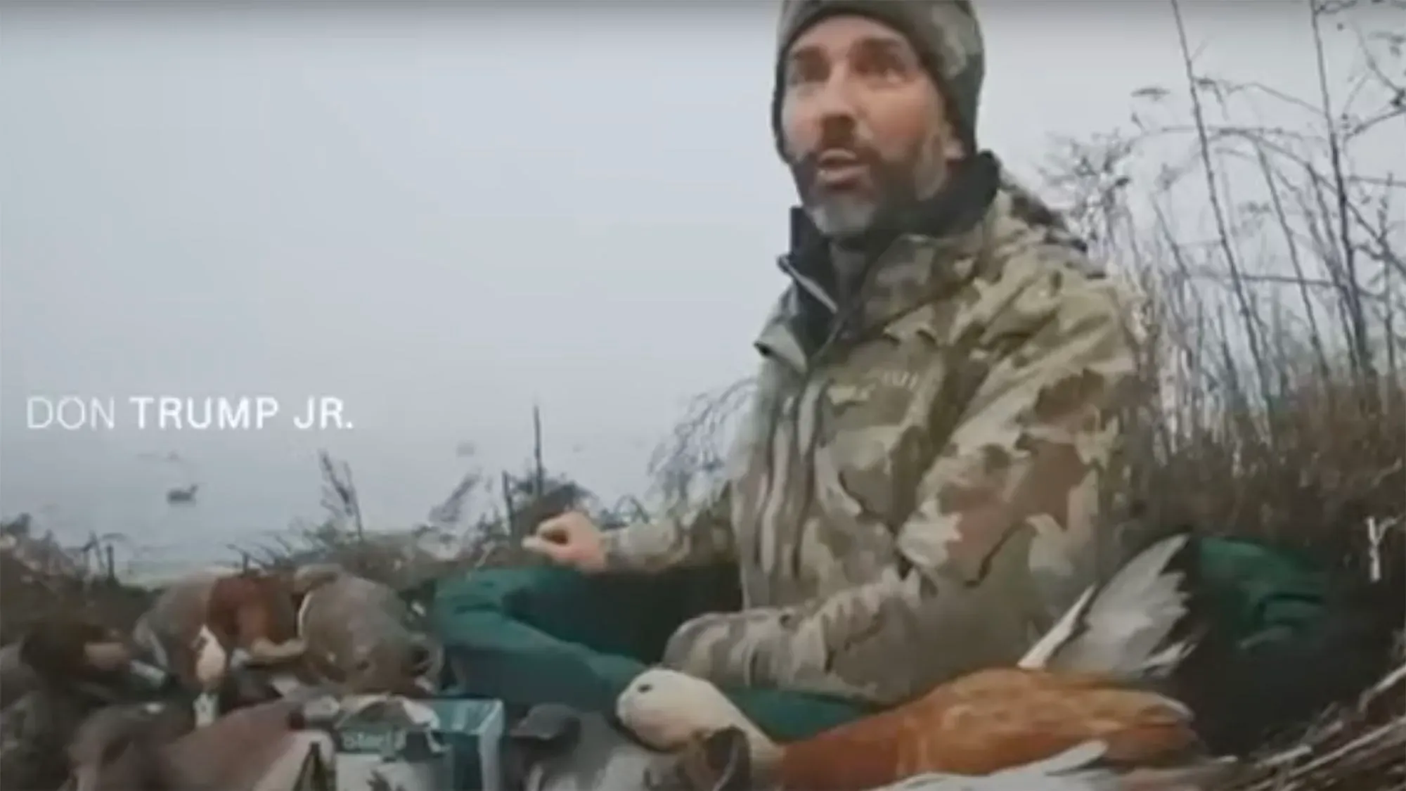 دونالد ترامب الابن يتحدث في منطقة صيد محاطة بطيور نافقة، مع التركيز على انتهاكات الصيد في بحيرة البندقية.