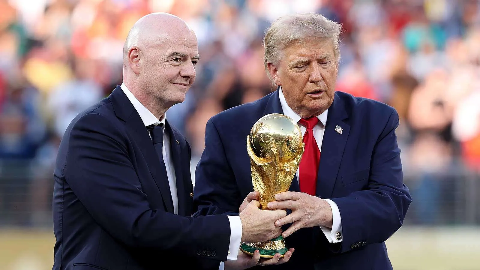 دونالد ترامب وجياني إنفانتينو يحملان كأس العالم معاً في حدث رياضي، في سياق دعم سياسي لرئيس الاتحاد الدولي لكرة القدم.