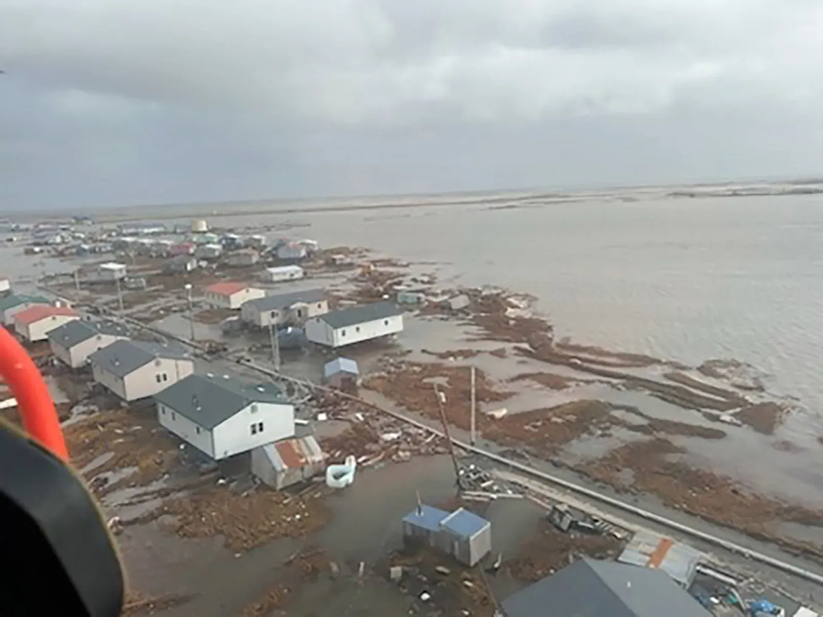 تظهر الصورة مشهدًا من كويجيلينجوك بألاسكا، حيث غمرت المياه المنازل بعد إعصار هالونج، مع أضرار واضحة في المنطقة.