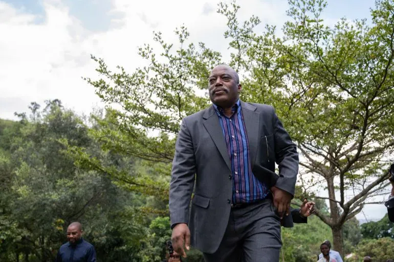 جوزيف كابيلا، الرئيس السابق لجمهورية الكونغو الديمقراطية، يسير في منطقة طبيعية، وسط أشجار، بعد صدور حكم بالإعدام غيابيًا ضده.