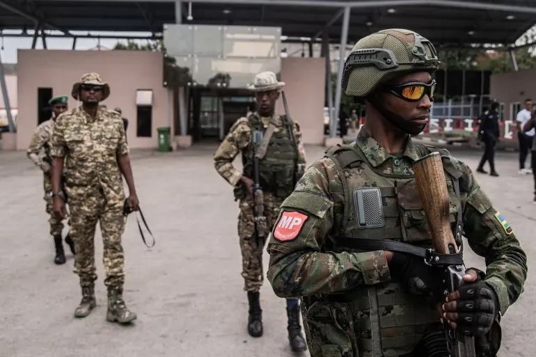 جنود من القوات الرواندية يرتدون زيهم العسكري، يراقبون الوضع في منطقة تشهد توترات أمنية بسبب النزاع في شرق جمهورية الكونغو الديمقراطية.