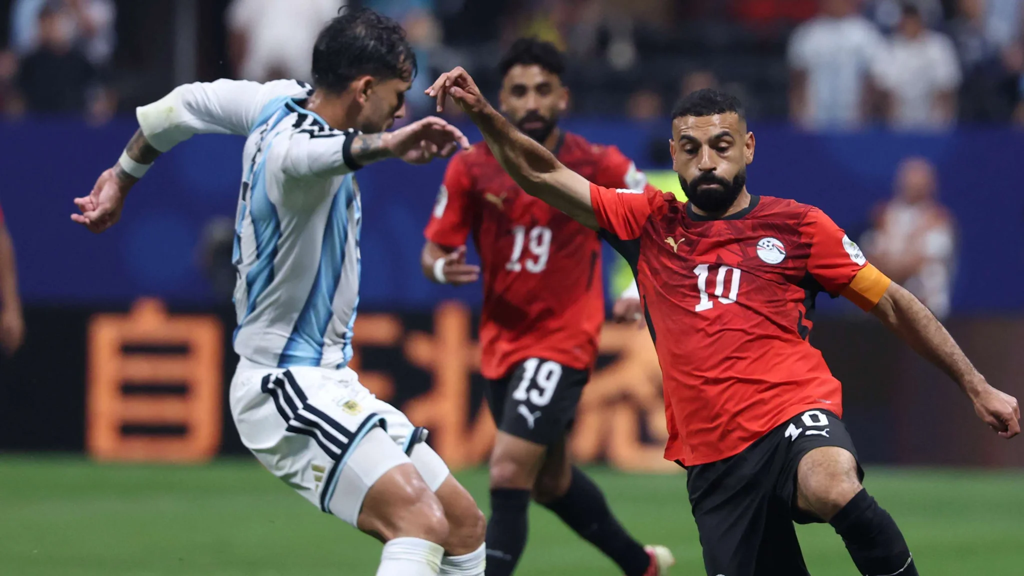 محمد صلاح قائد منتخب مصر يراوغ لاعب الأرجنتين خلال مباراة كأس العالم 2026 المثيرة للجدل التي شهدت قرارات تحكيمية مثيرة وانتقادات لاتساق الـ VAR.