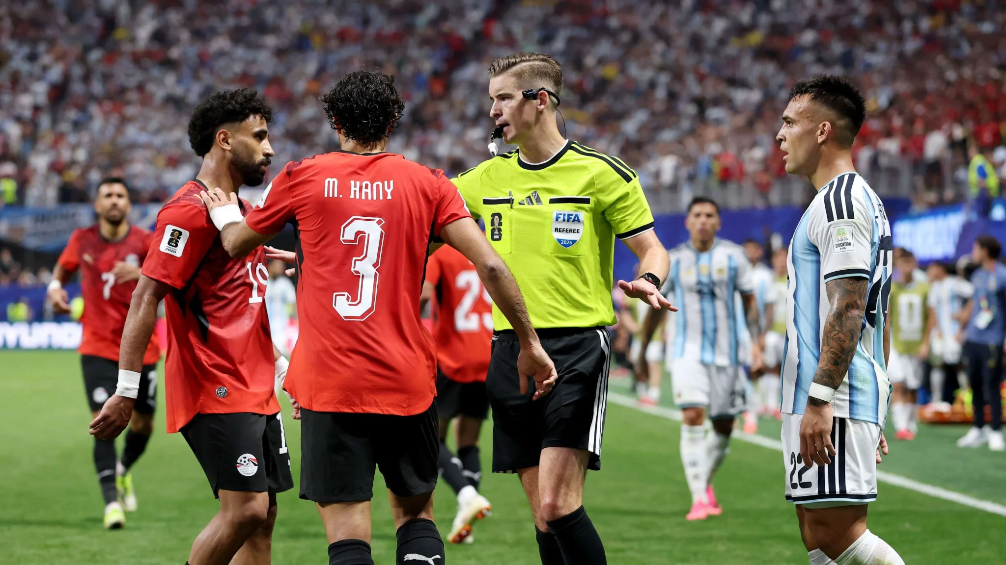 حكم مباراة مصر والأرجنتين يتوسط لاعبي المنتخبين خلال كأس العالم 2026 وسط جدل تحكيمي وتقنية VAR أثرت على نتيجة المباراة.
