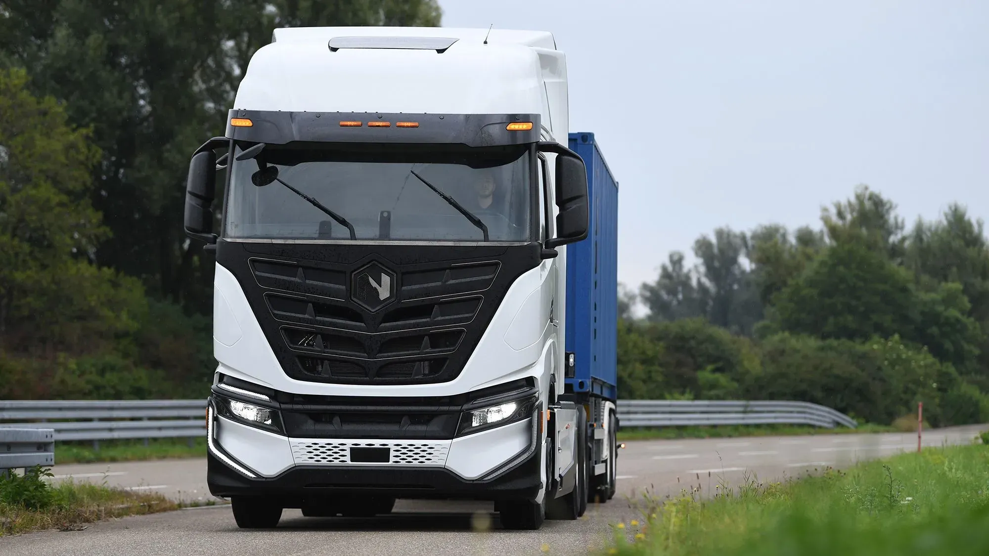 شاحنة كهربائية حديثة من شركة نيكولا تسير على طريق، تعكس جهود الشركة في تطوير تكنولوجيا النقل المستدام.