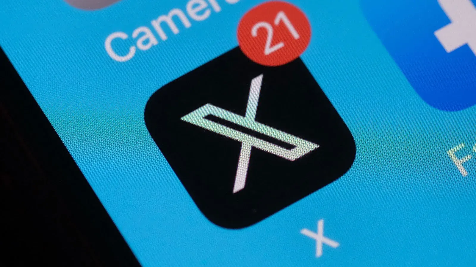 شعار تطبيق X على شاشة هاتف ذكي، مع إشعار يوضح وجود 21 تنبيهًا، مما يعكس أهمية المنصة في عالم التواصل الاجتماعي.