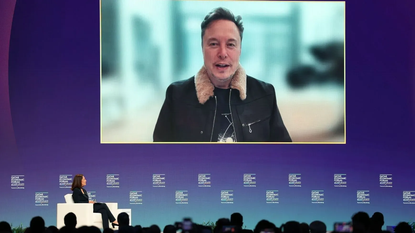 إيلون ماسك يتحدث عبر الفيديو خلال منتدى بلومبرغ الاقتصادي في الدوحة، مؤكدًا التزامه برئاسة تسلا في السنوات القادمة.