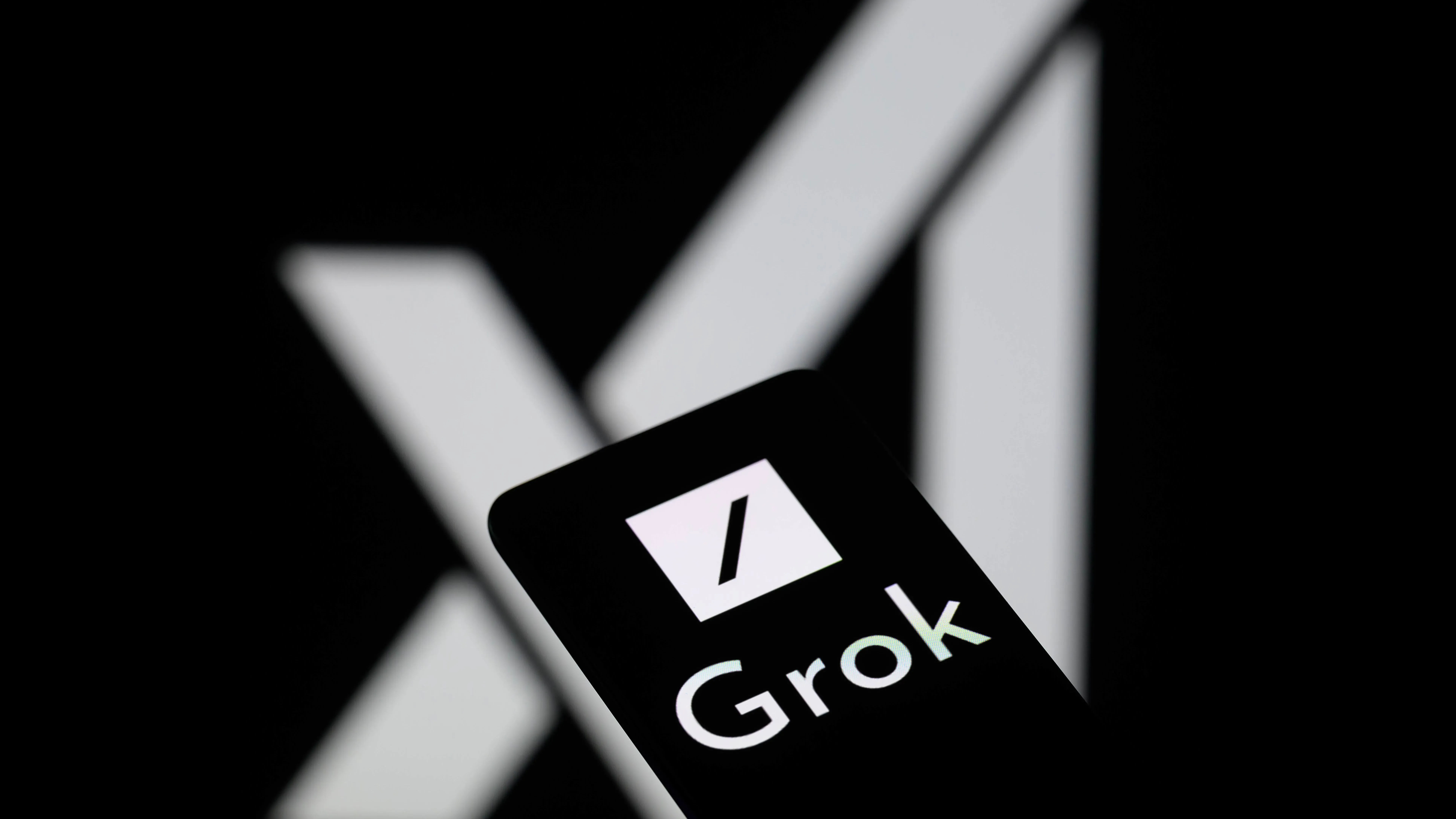 شاشة هاتف تعرض شعار "Grok" مع خلفية داكنة، تعكس استخدام الذكاء الاصطناعي في منصة X.