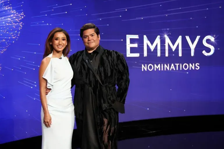 مقدمان يعلنان عن ترشيحات جوائز إيمي 2025 في مسرح وولف بلوس أنجلوس، مع خلفية تحمل شعار الجوائز.