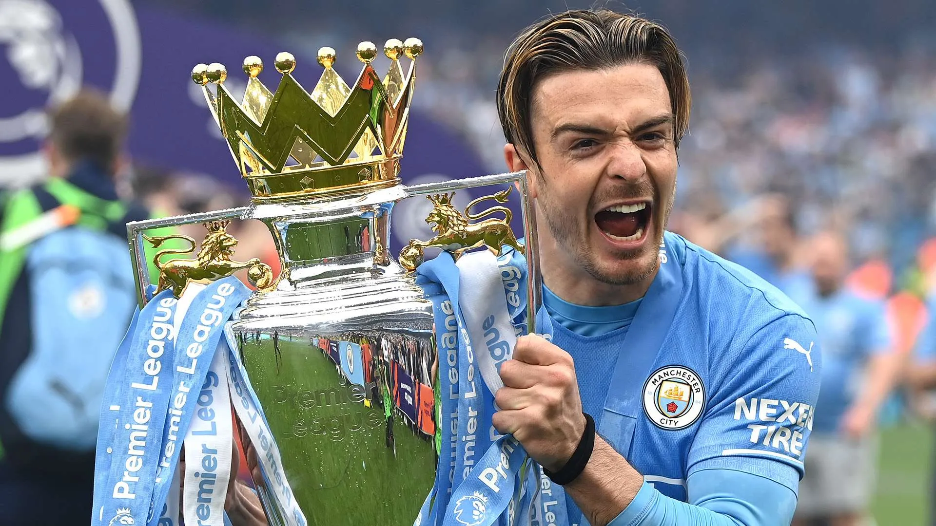جاك جريليش لاعب مانشستر سيتي يحتفل بحمل كأس الدوري الإنجليزي الممتاز بفوز الفريق بالثلاثية في موسم 2023-2024.