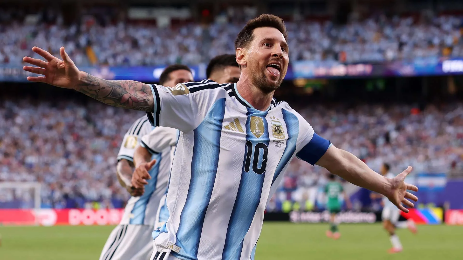 ليونيل ميسي يحتفل بهدف مع منتخب الأرجنتين في مباراة دولية، مع تفاعل الجمهور في خلفية الملعب.