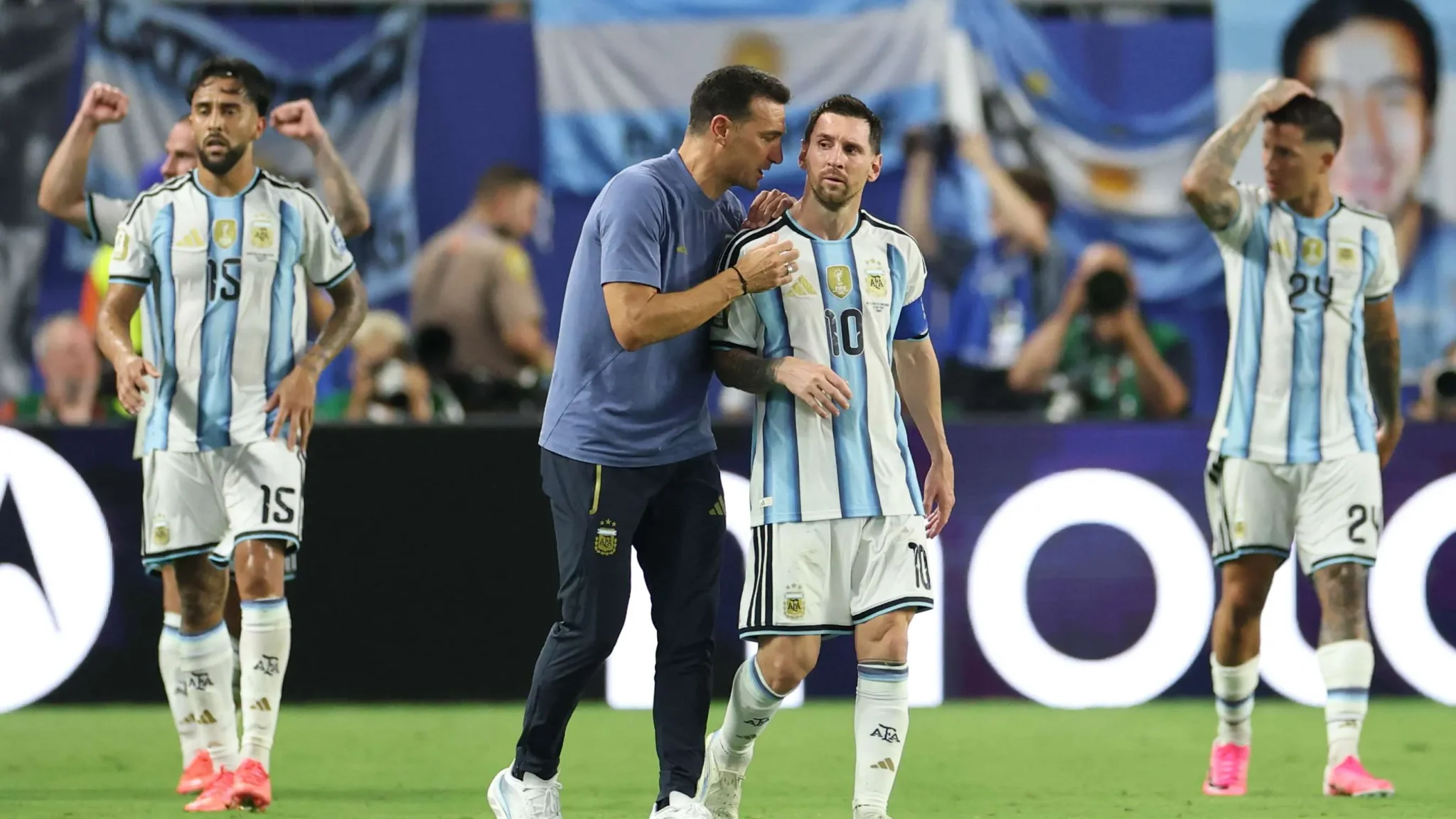 لاعبو منتخب الأرجنتين يحتفلون بعد فوزهم في مباراة حاسمة، مع تركيز على ليونيل ميسي ومدربه خلال استعدادهم لنصف نهائي كأس العالم.