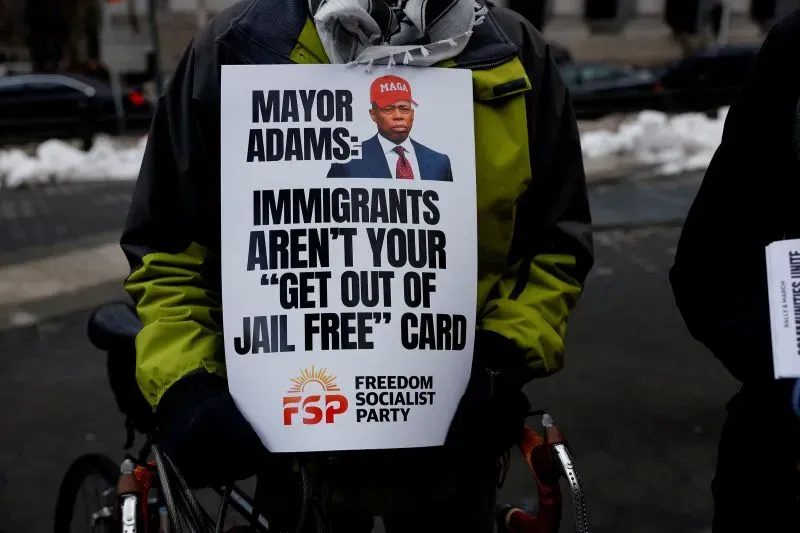 لافتة تحمل رسالة تطالب العمدة آدامز بعدم استخدام المهاجرين كوسيلة للتهرب من المسؤولية، خلال احتجاج في مدينة نيويورك.