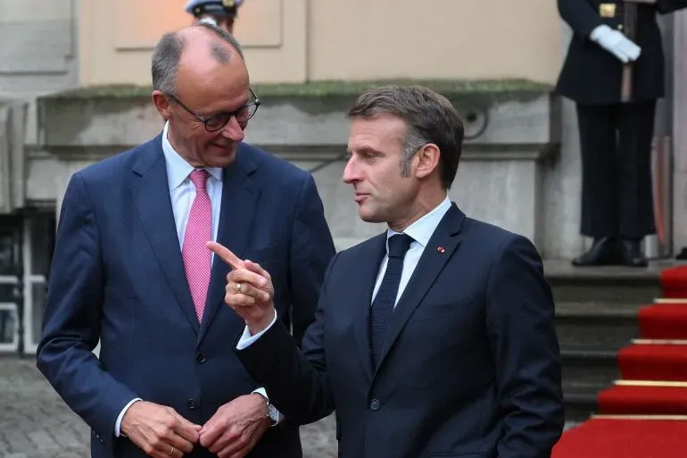 ميرتس وماكرون يتحدثان في برلين قبل مأدبة عشاء، وسط توقعات بتقدم في المفاوضات التجارية بين الاتحاد الأوروبي والولايات المتحدة.